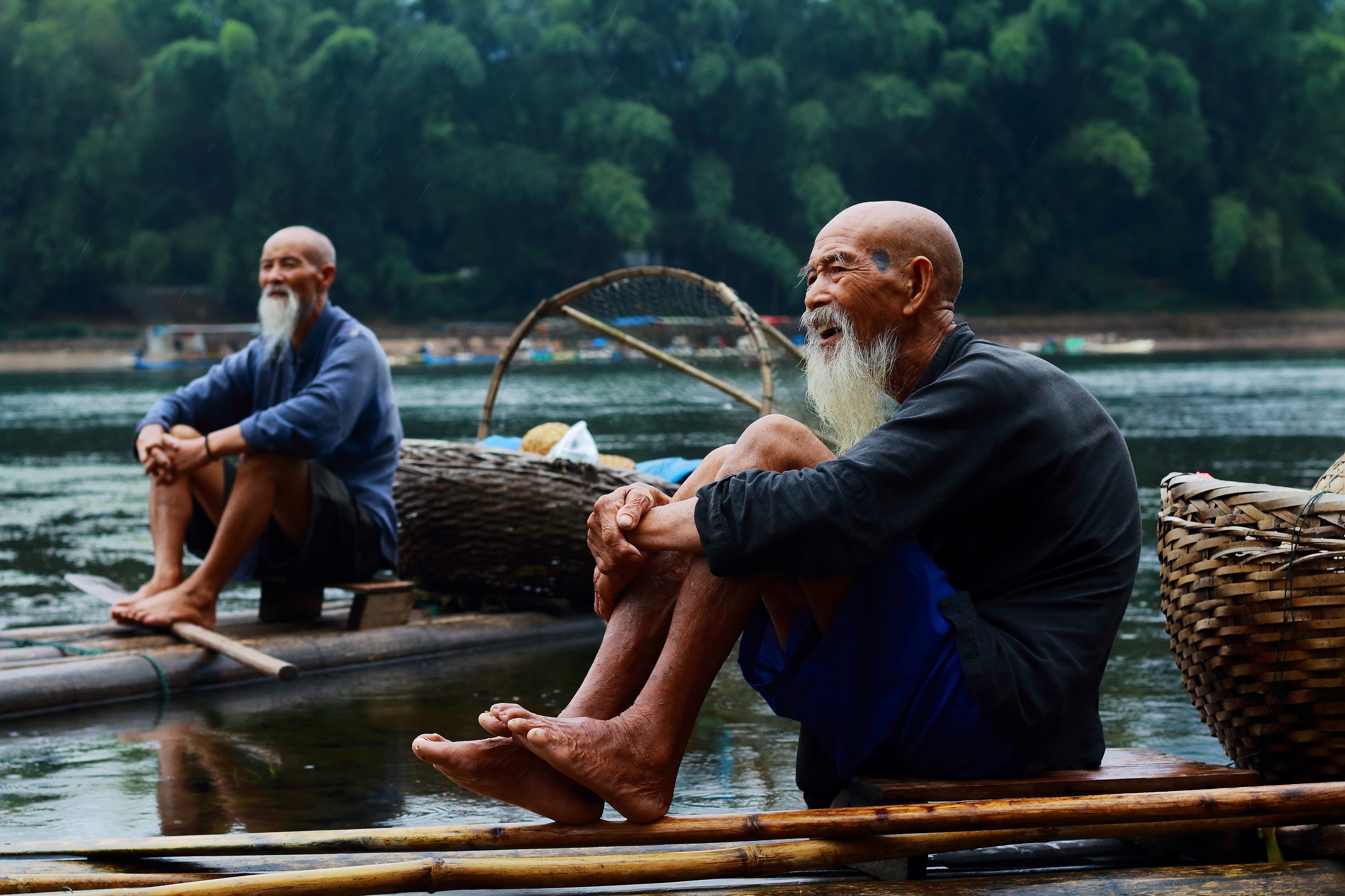 Two men sitting on riverbank photo