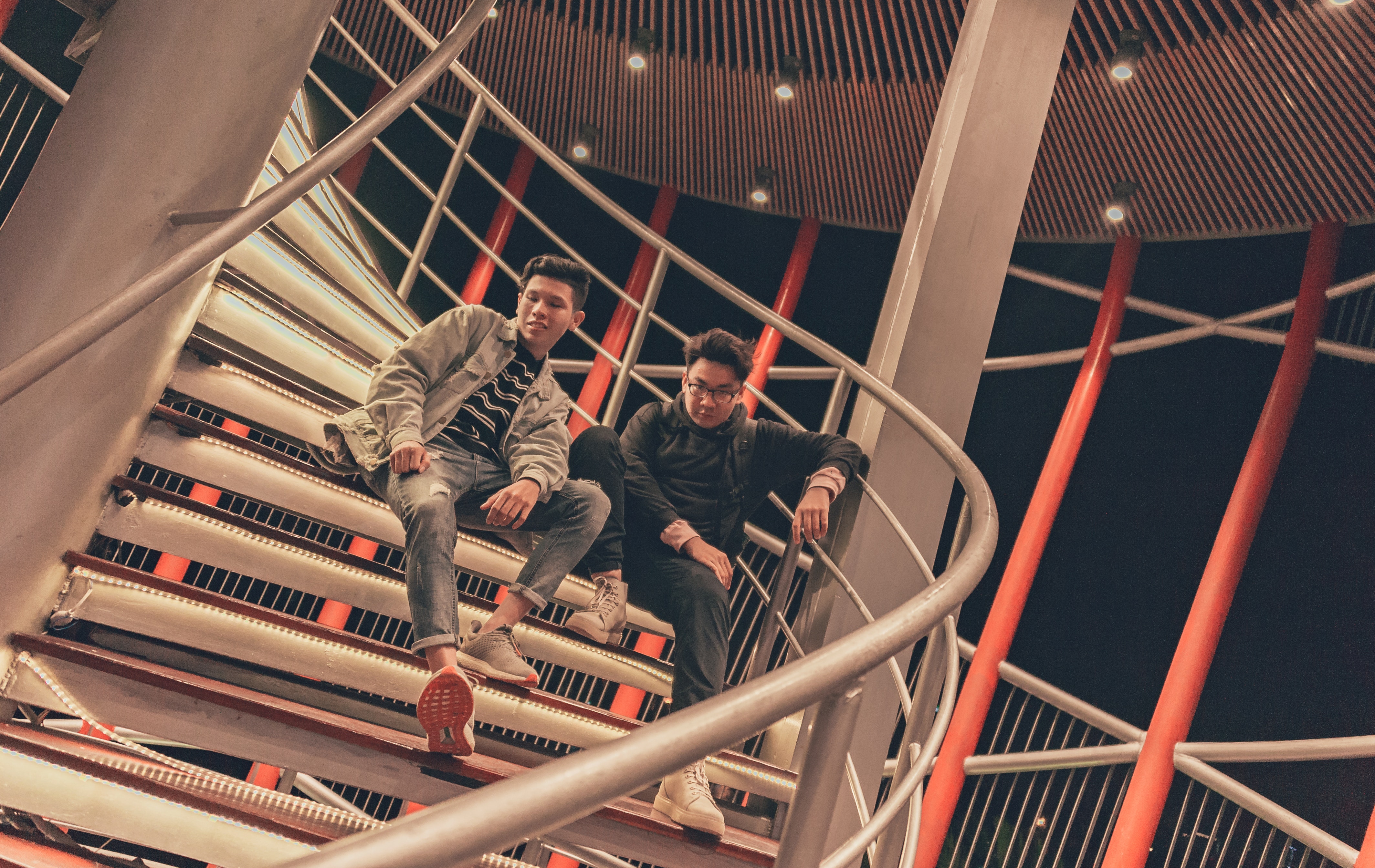 Two men sitting on spiral stairway photo
