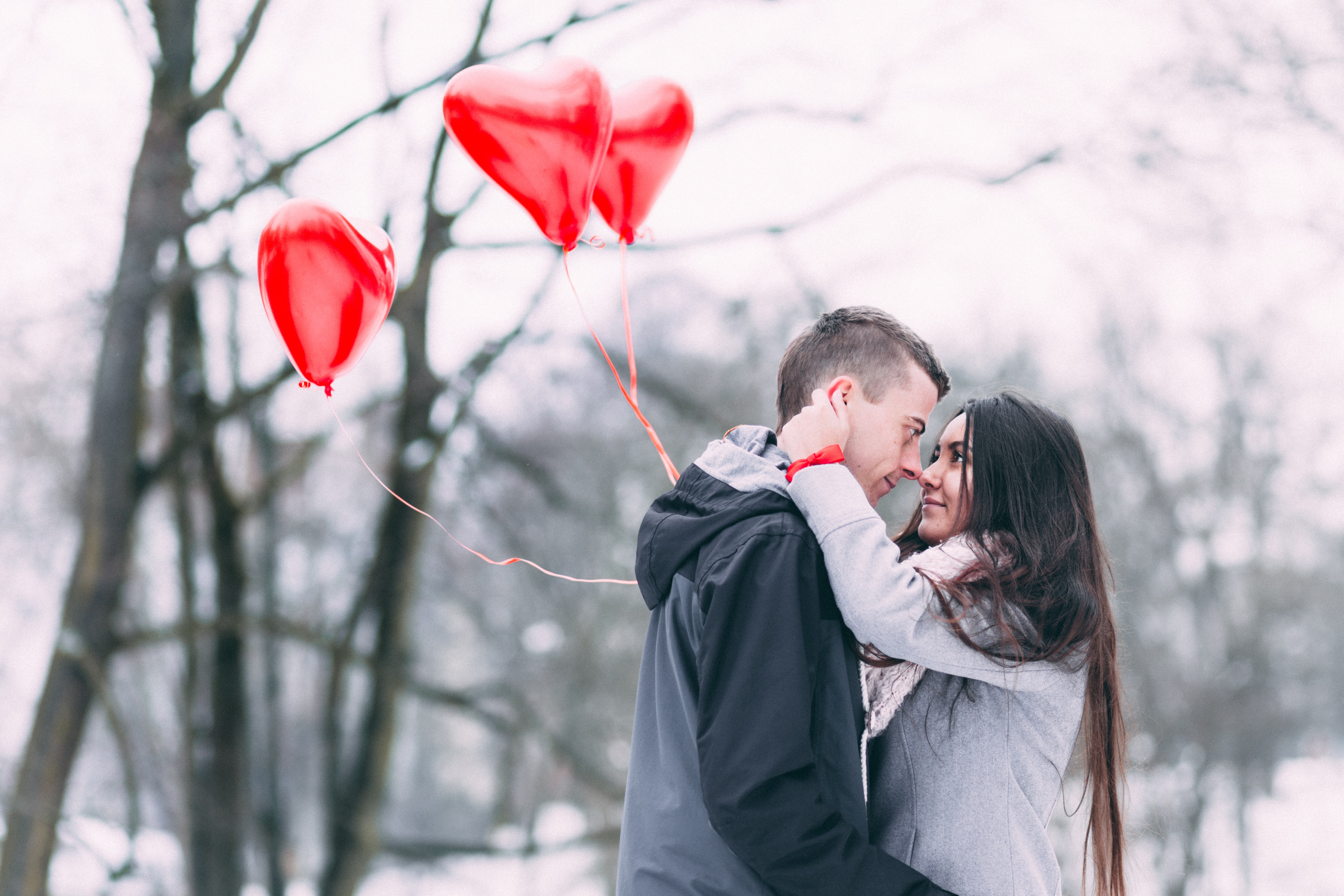 Two people with heart shape balloons in winter photo