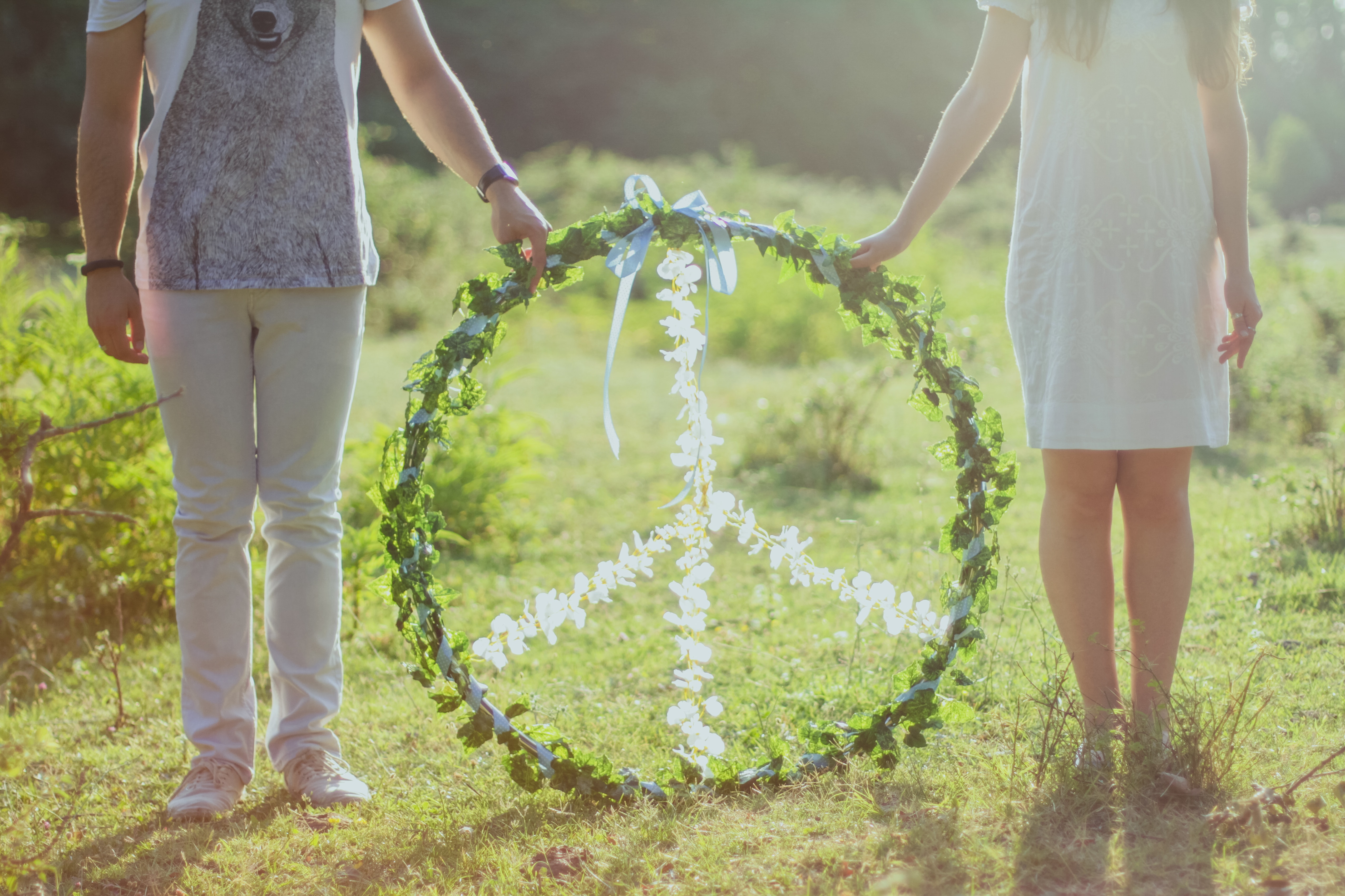 Two person holding white and green peace wreath photo