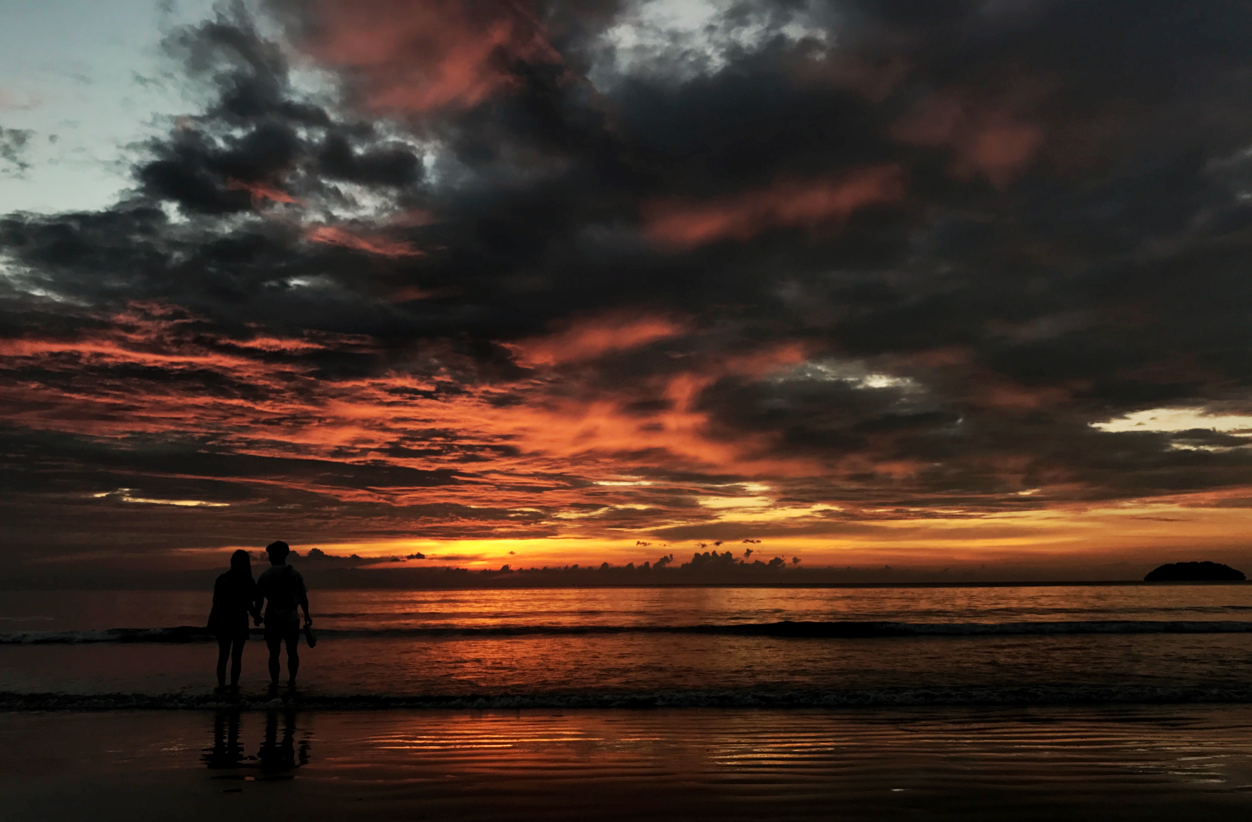 Two person standing on beach silhouette photo