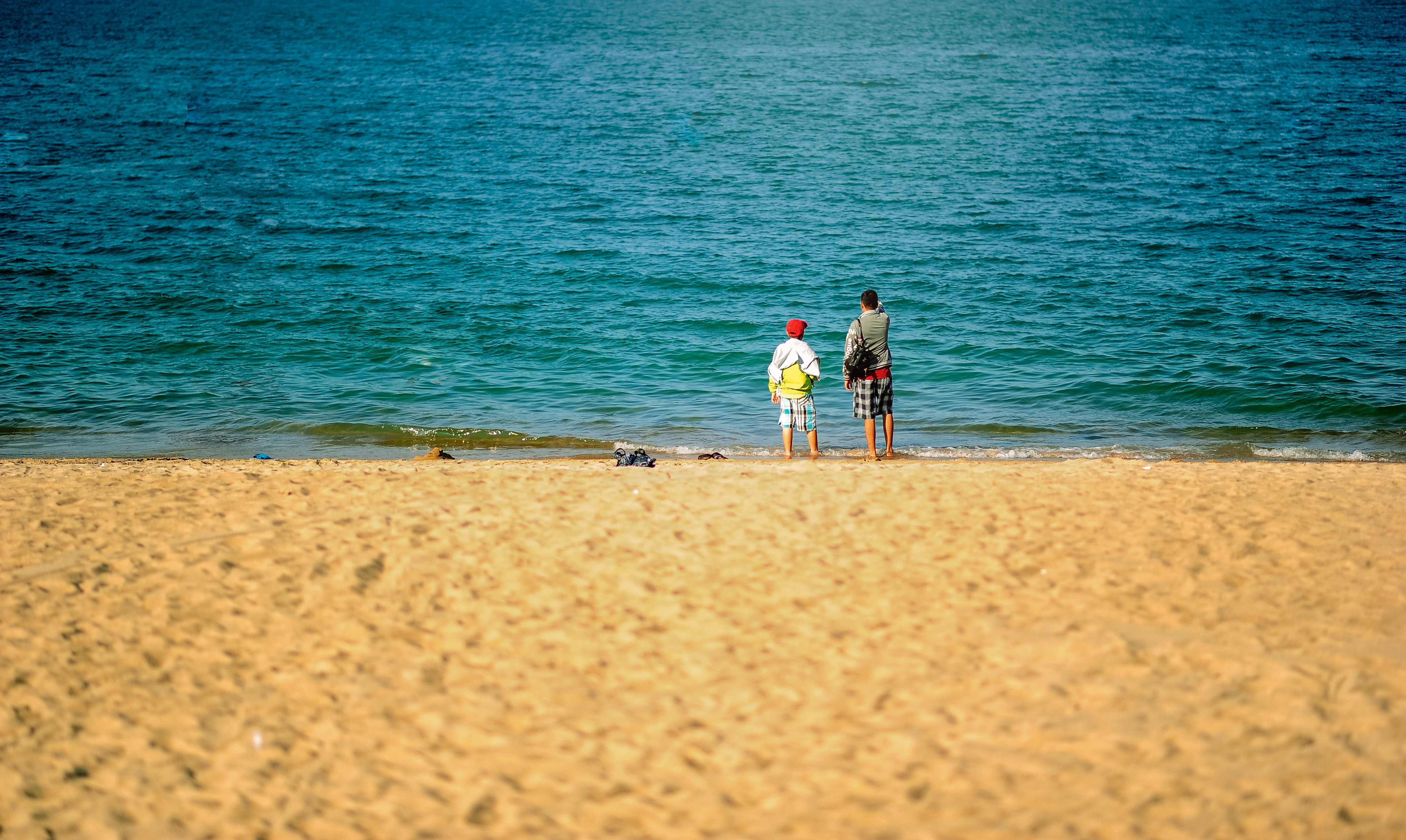 Two persons standing near beach photo