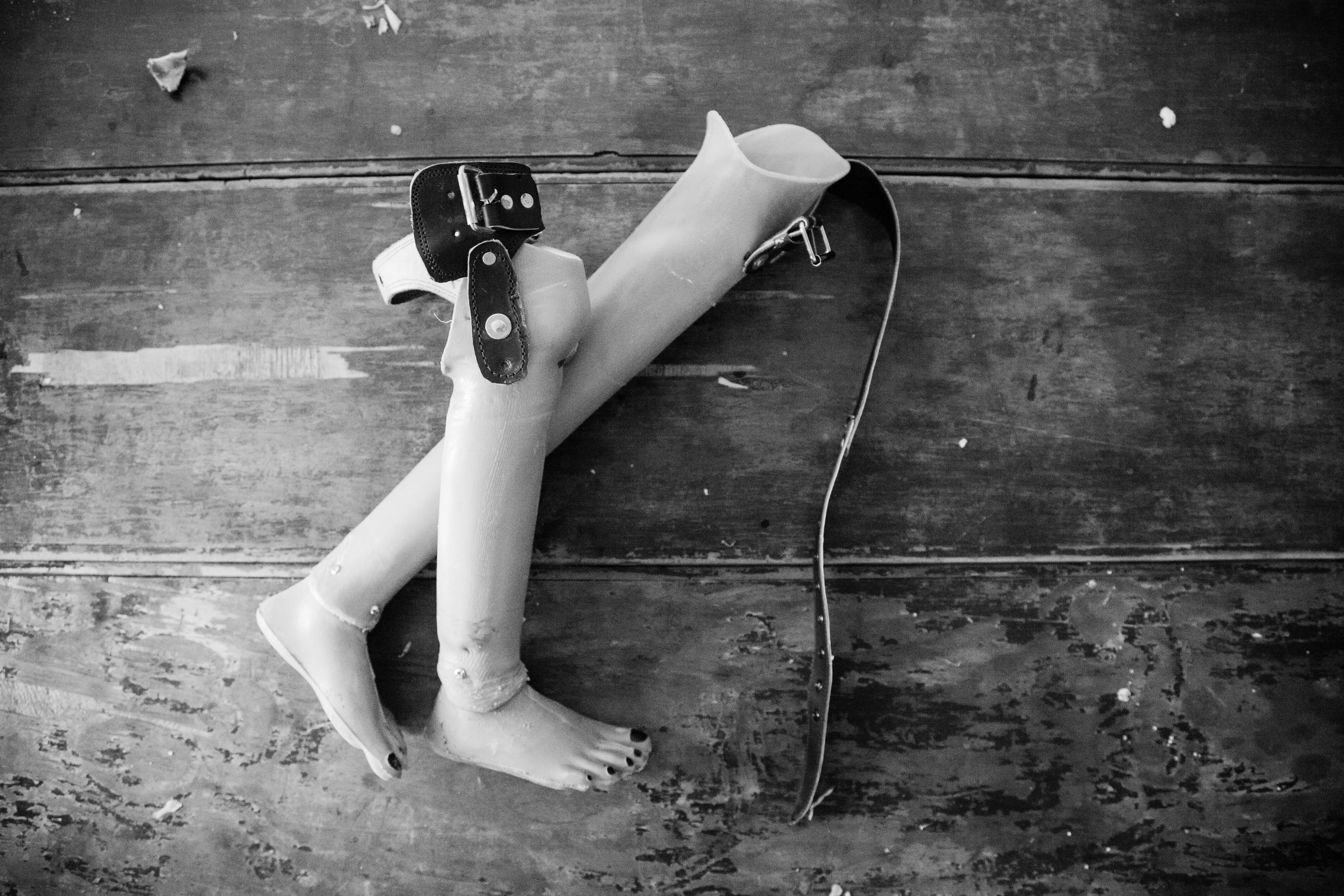 Two prosthetic legs on wooden surface photo