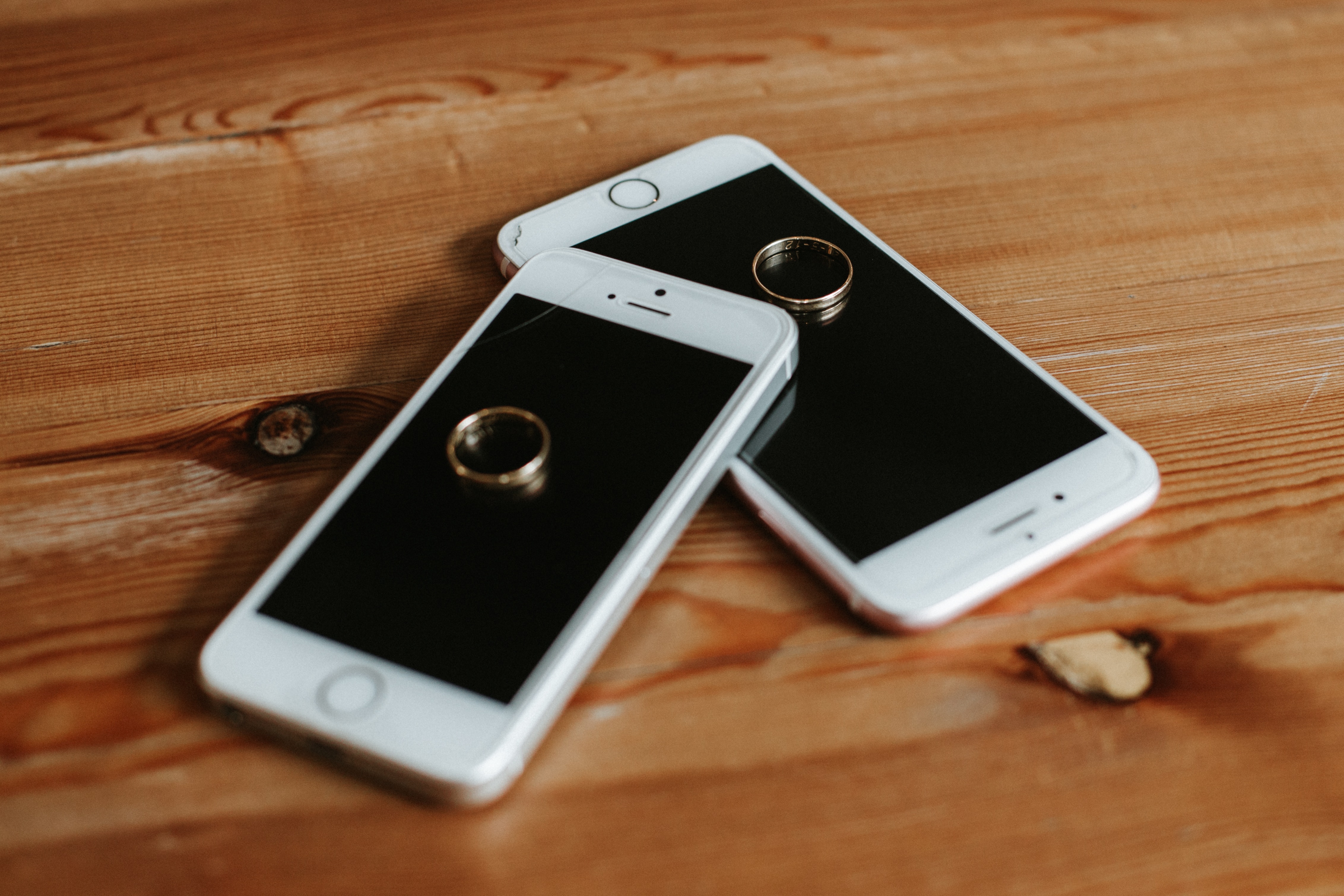 Two rose gold iphone 6s on brown wooden surface photo