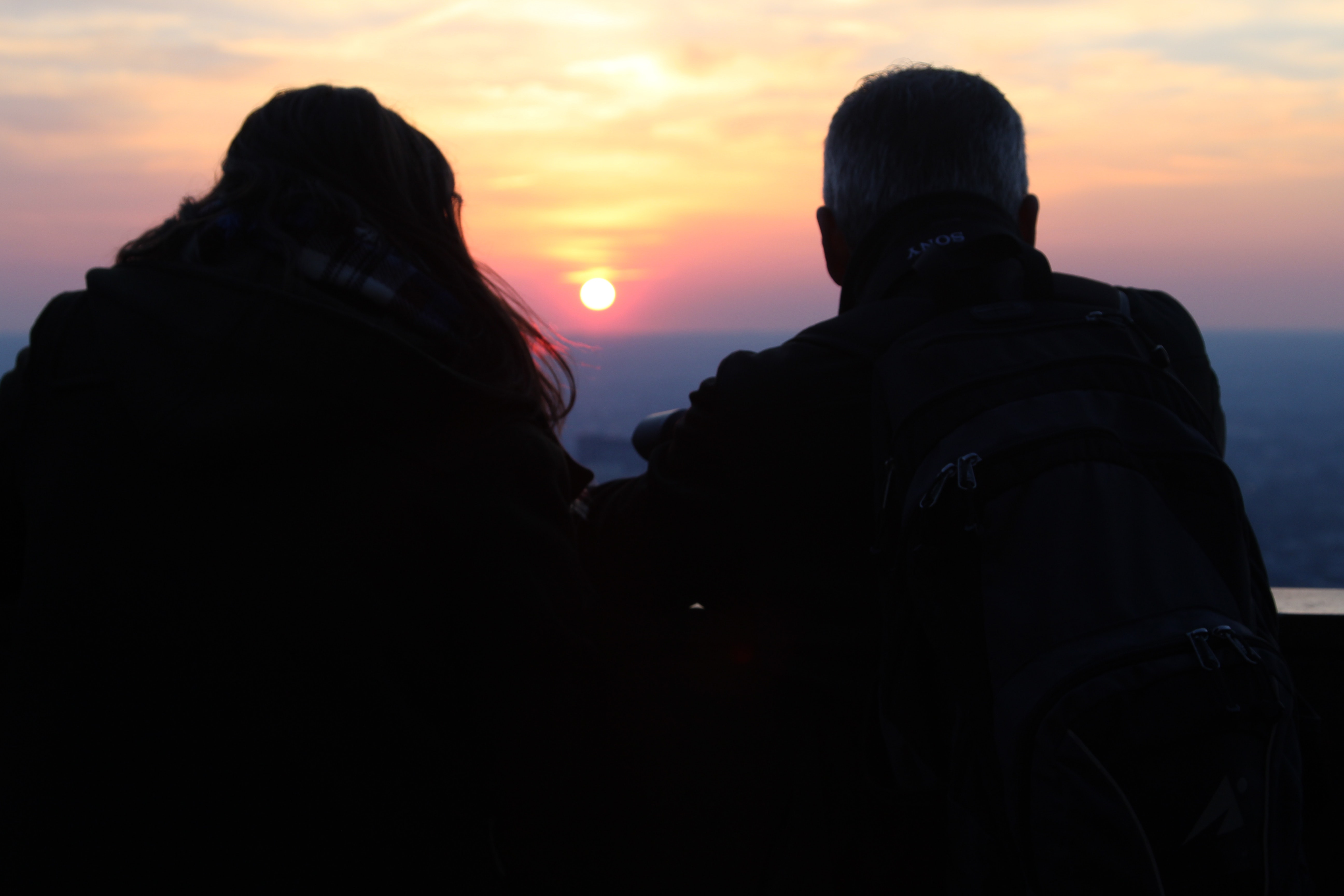 Two silhouette person watching the sunset photo