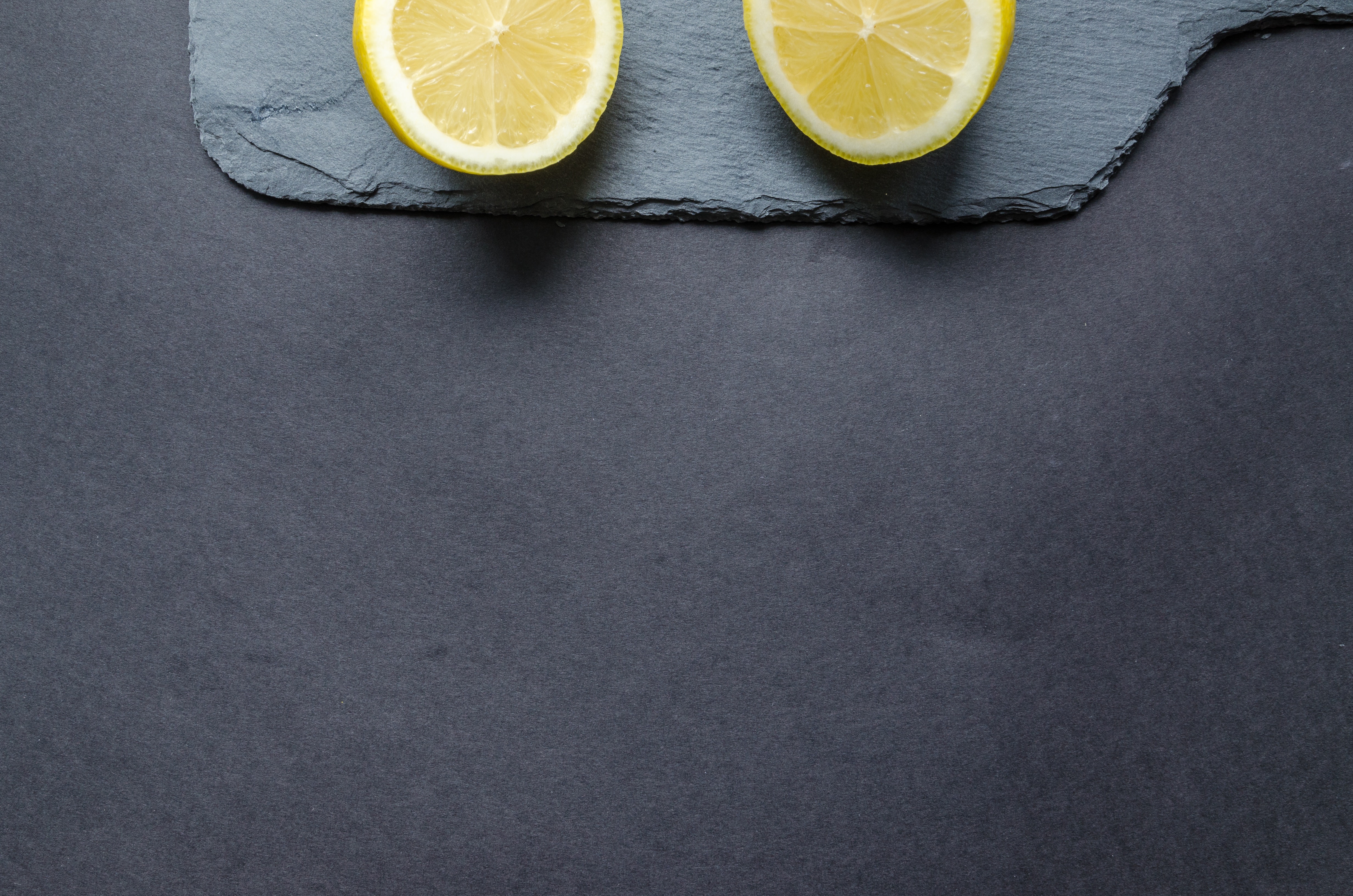 Two sliced lemons on black surface photo