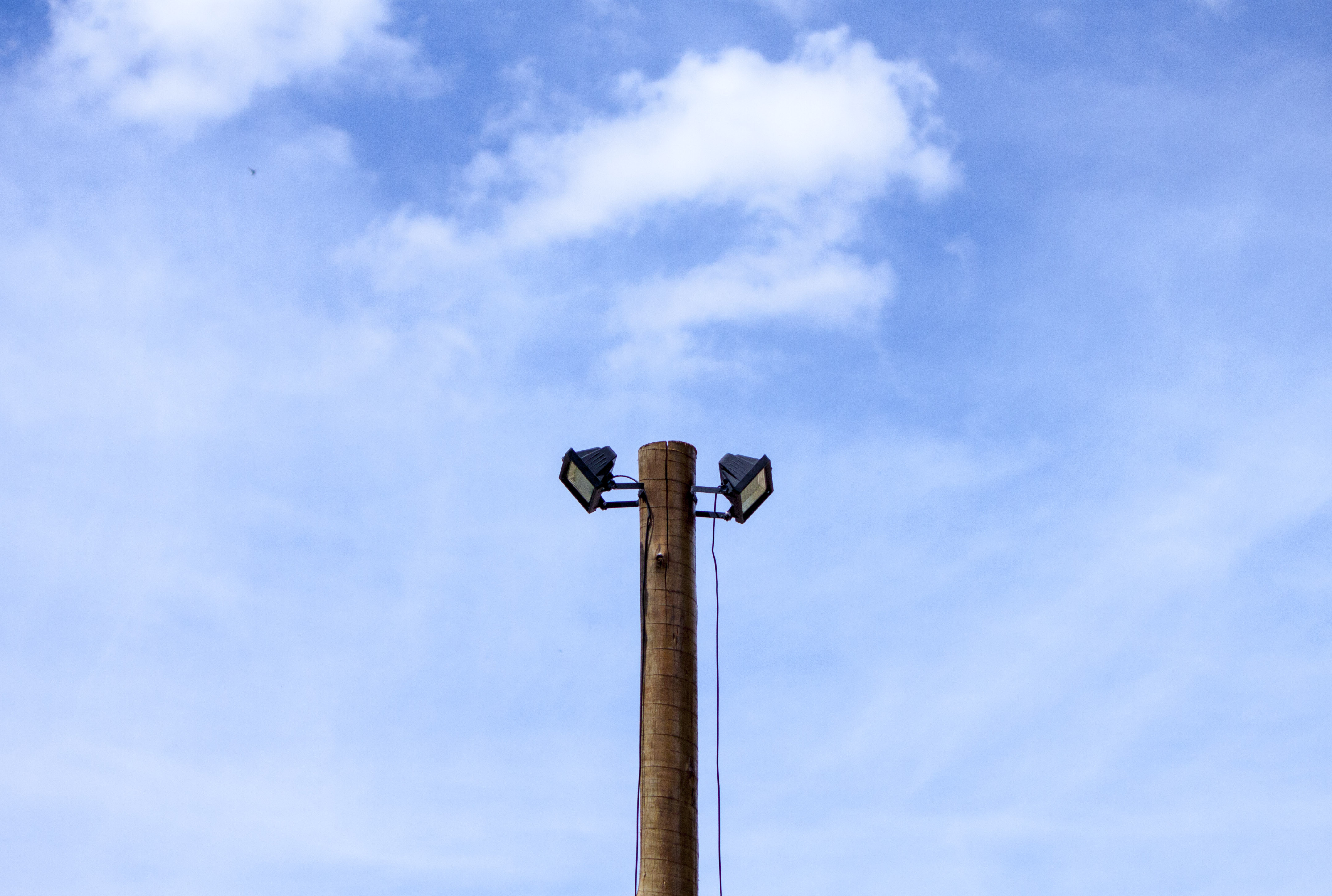 Two spotlights atop a wooden post photo