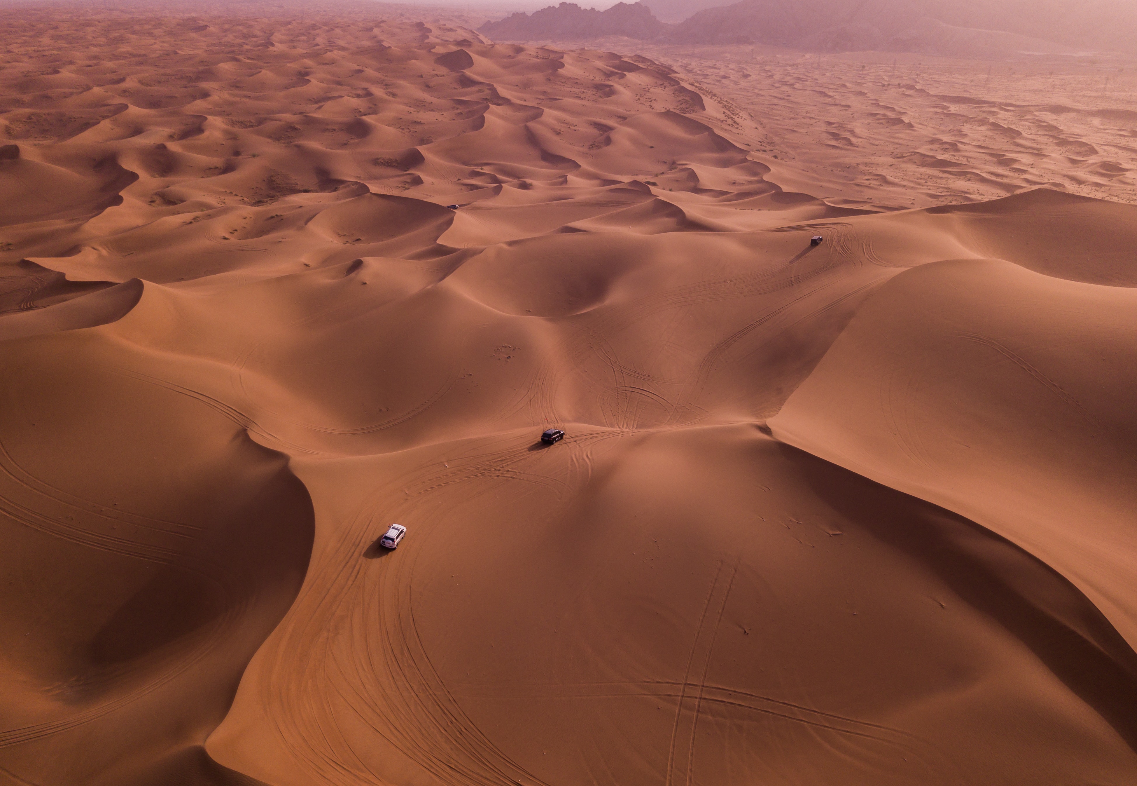 Two vehicles on desert dunes photo
