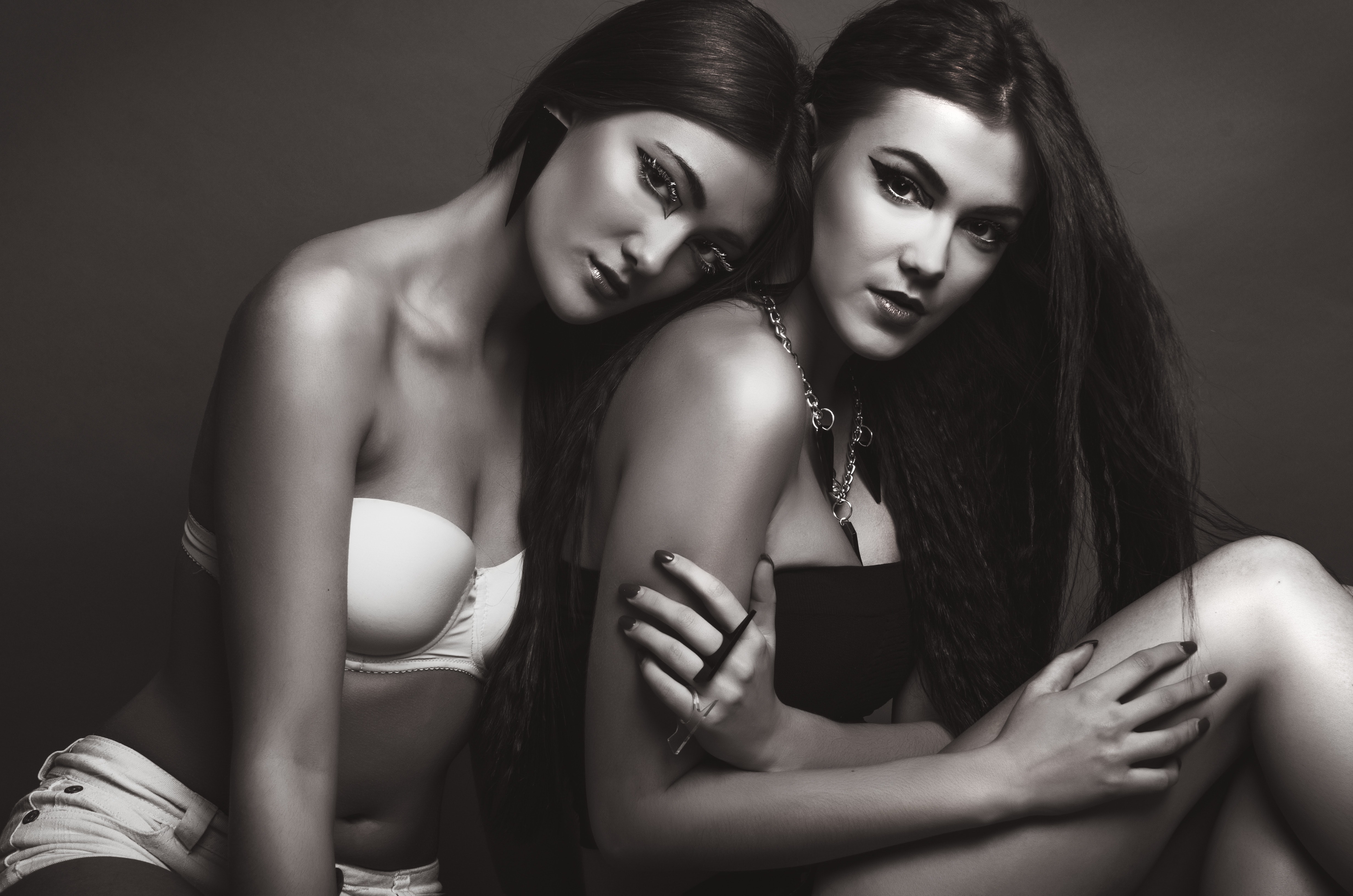 Two woman wearing black and white brassiere photo