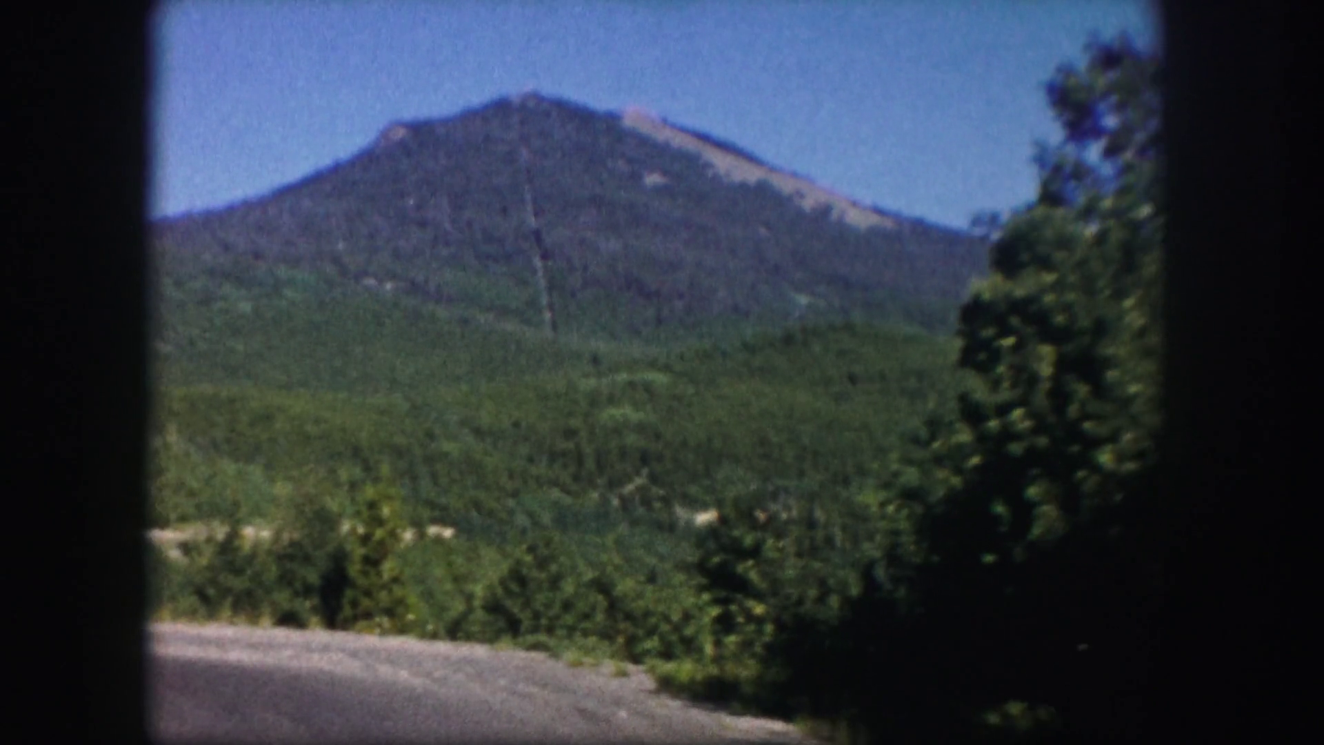 1958: large mountain under the blue sky beyond amazing greenery ...