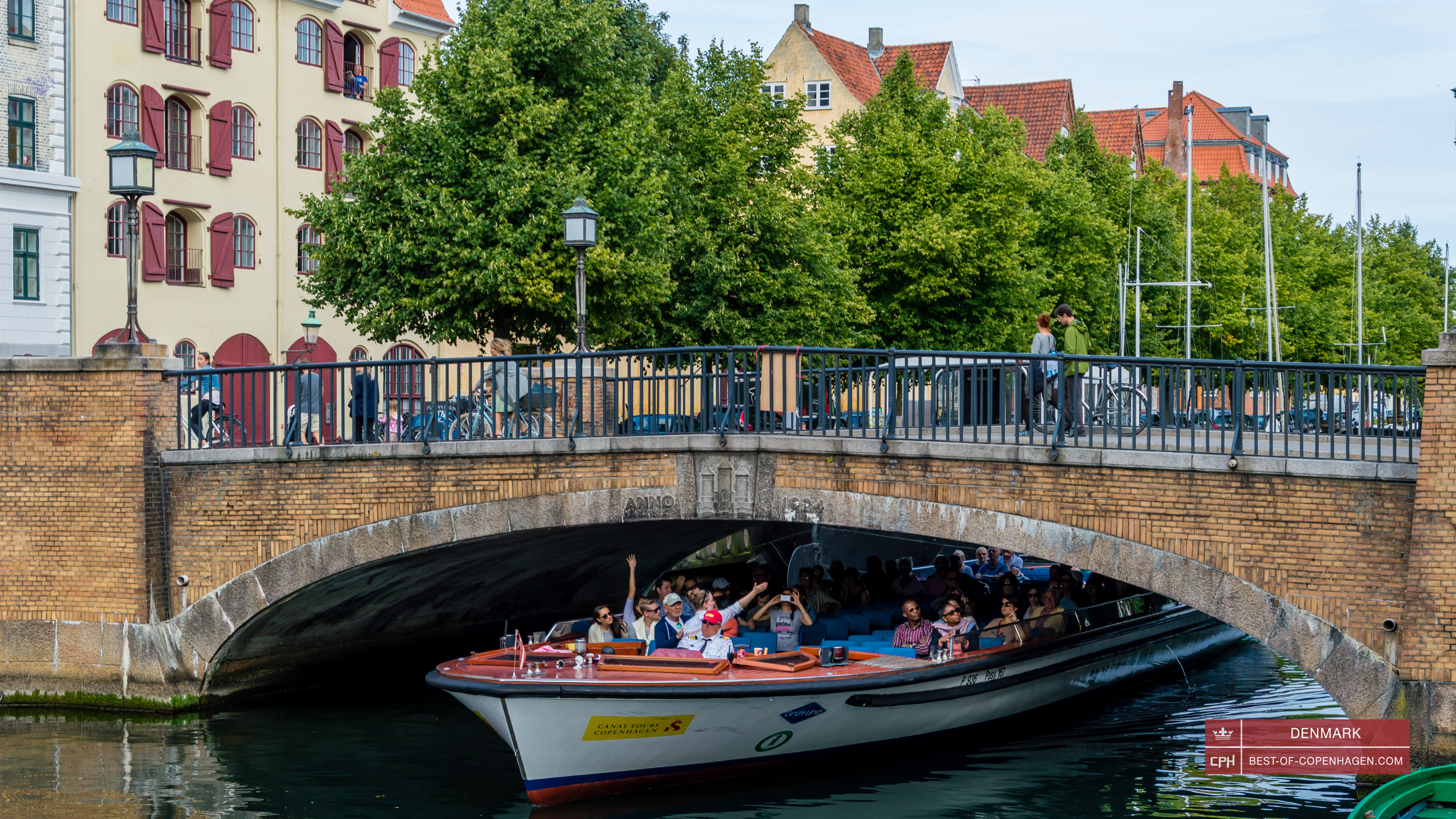 Copenhagen. Tourists on canal tour boat passing under the bridge