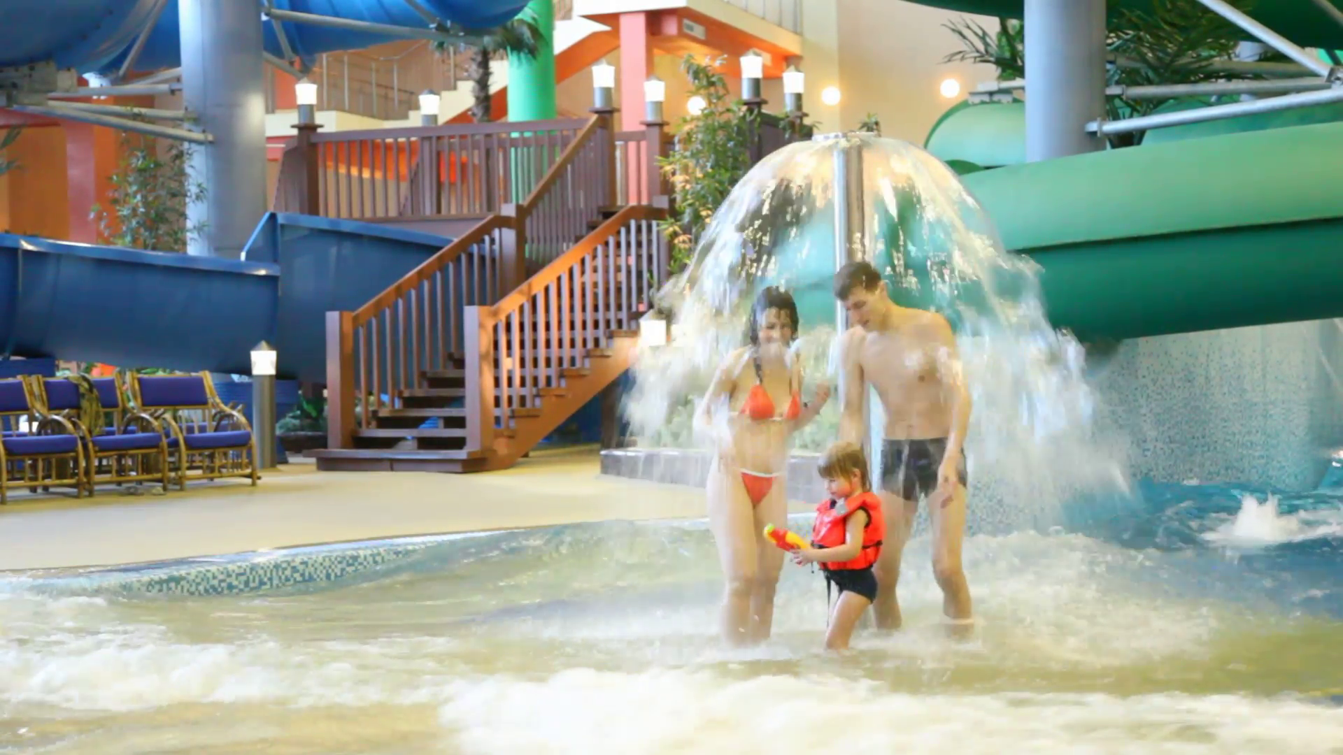 woman runs under fountain in a pool in indoor water park Stock Video ...