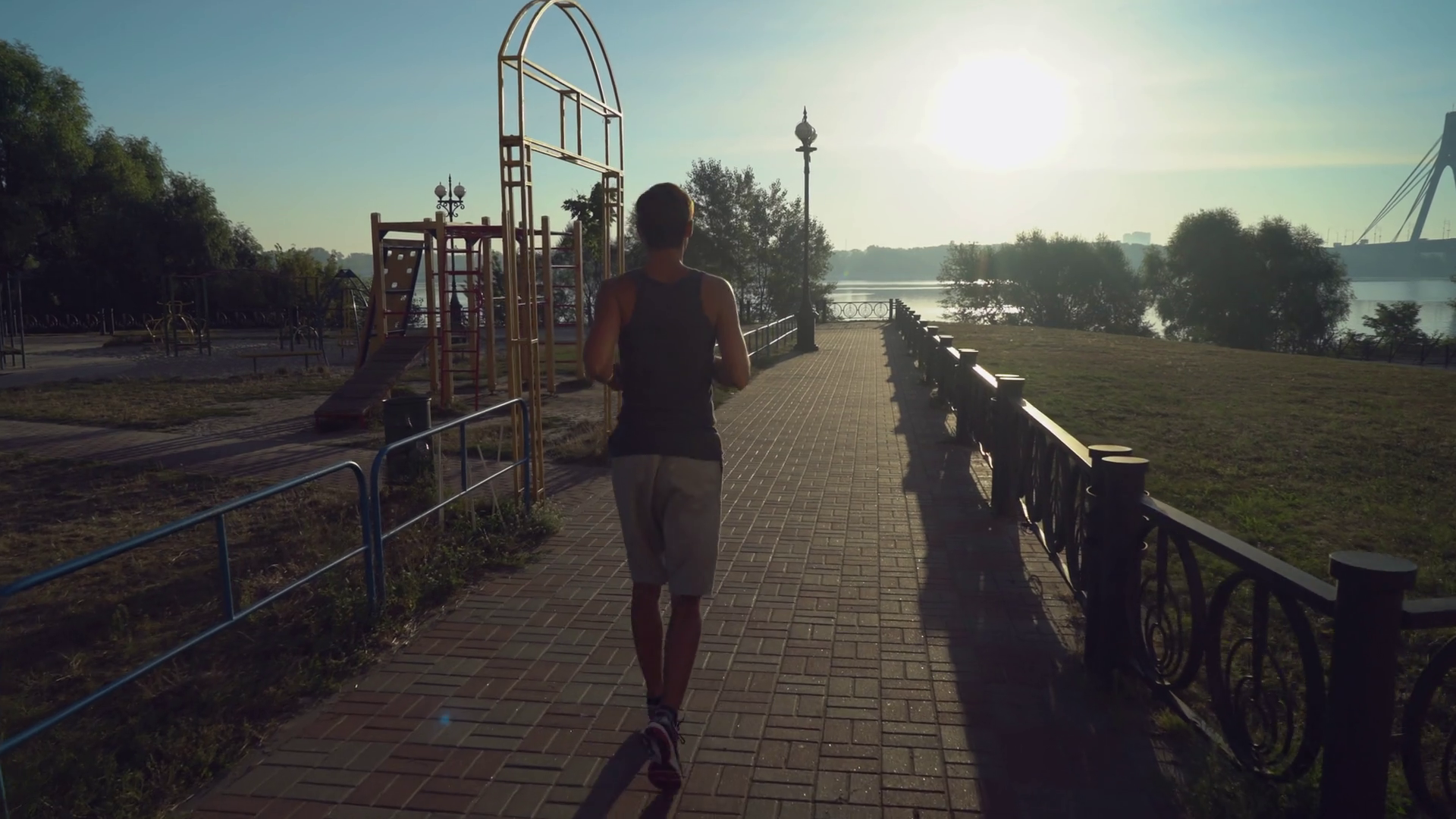 Jogger runs outdoor at sunrise in summer. Rear back view runner ...