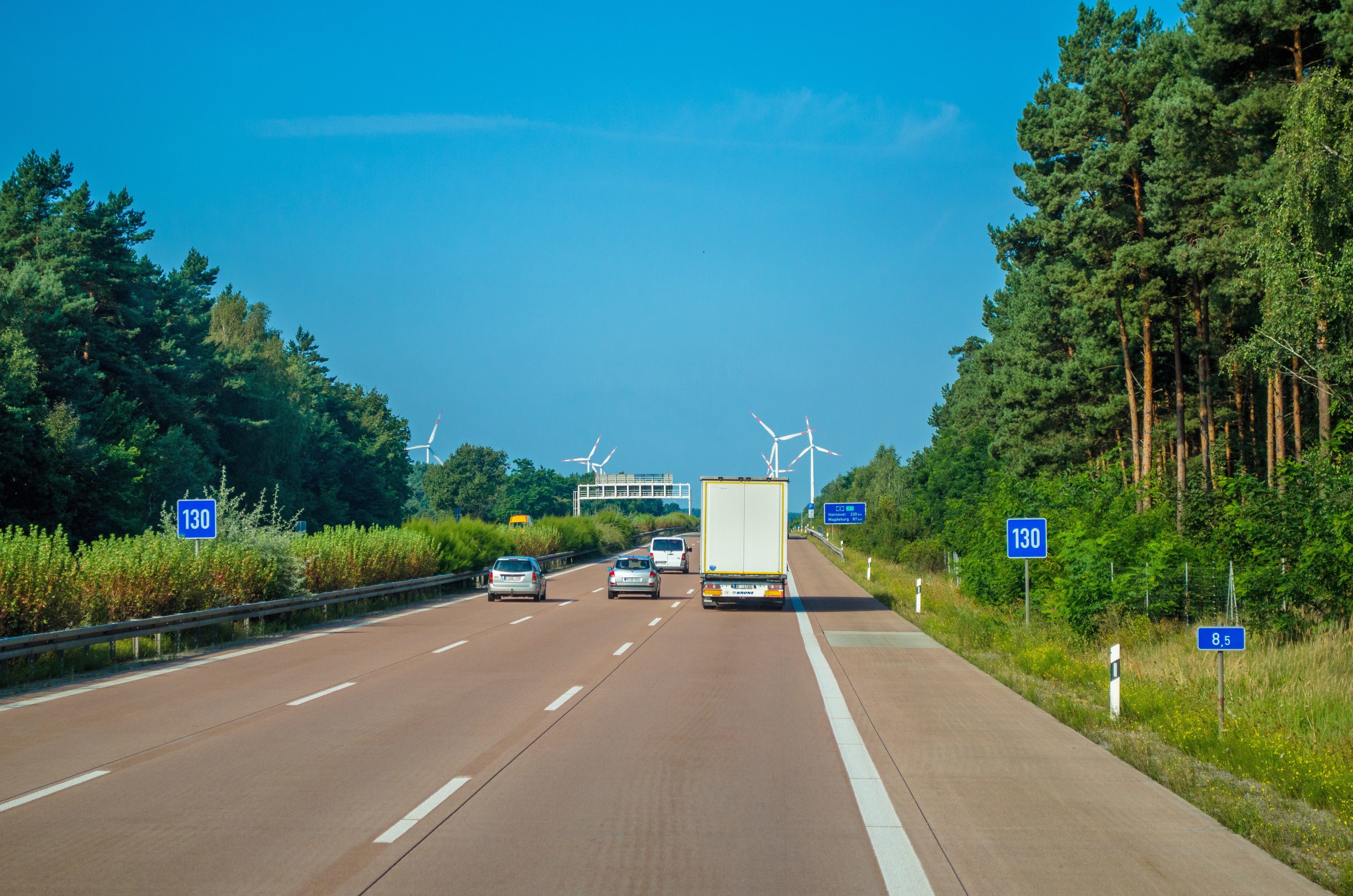 Vehicle driving on freeway towards wind turbines photo