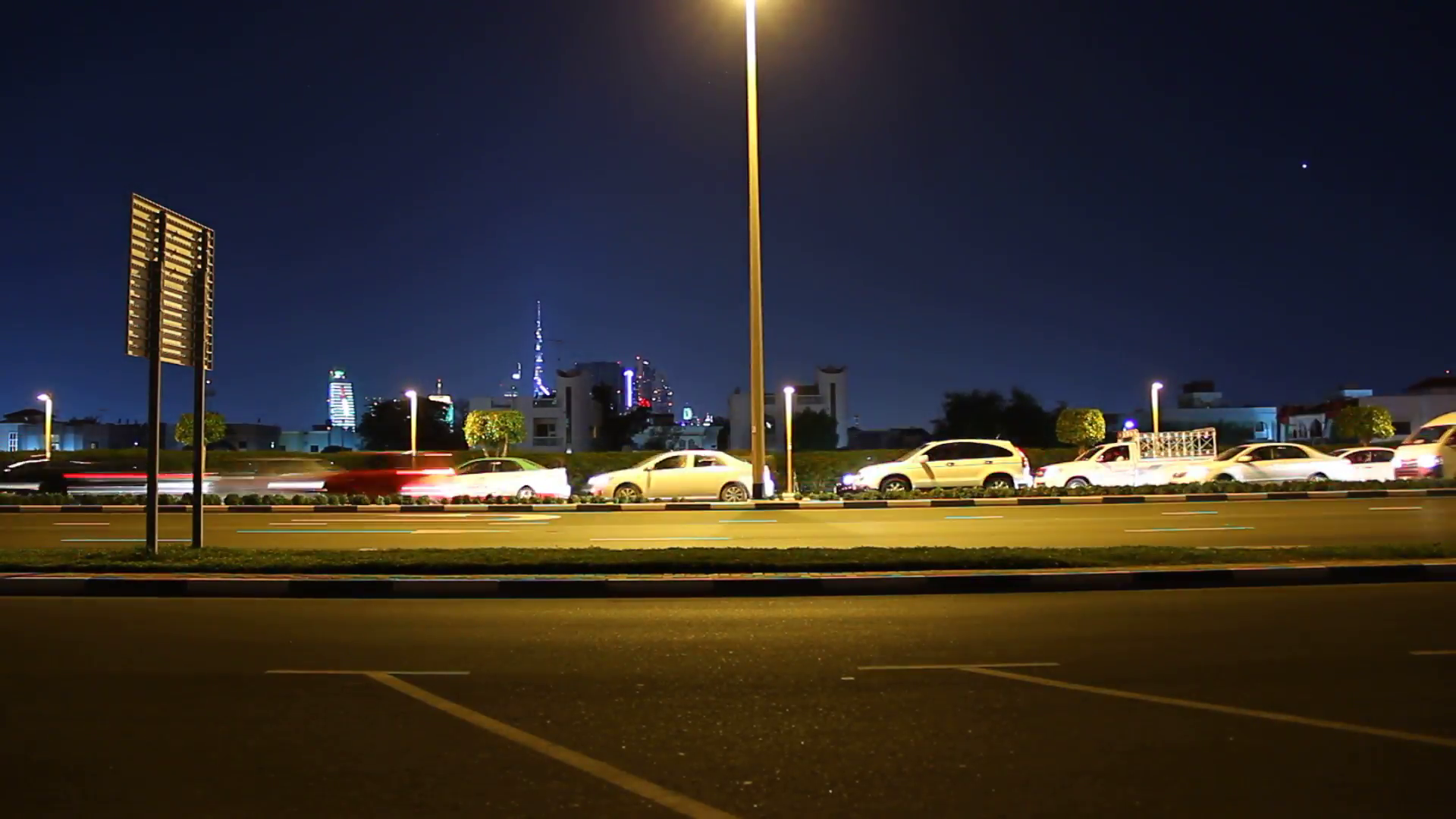 Night city road side view, time lapse. Cars sweep past, stop for a ...
