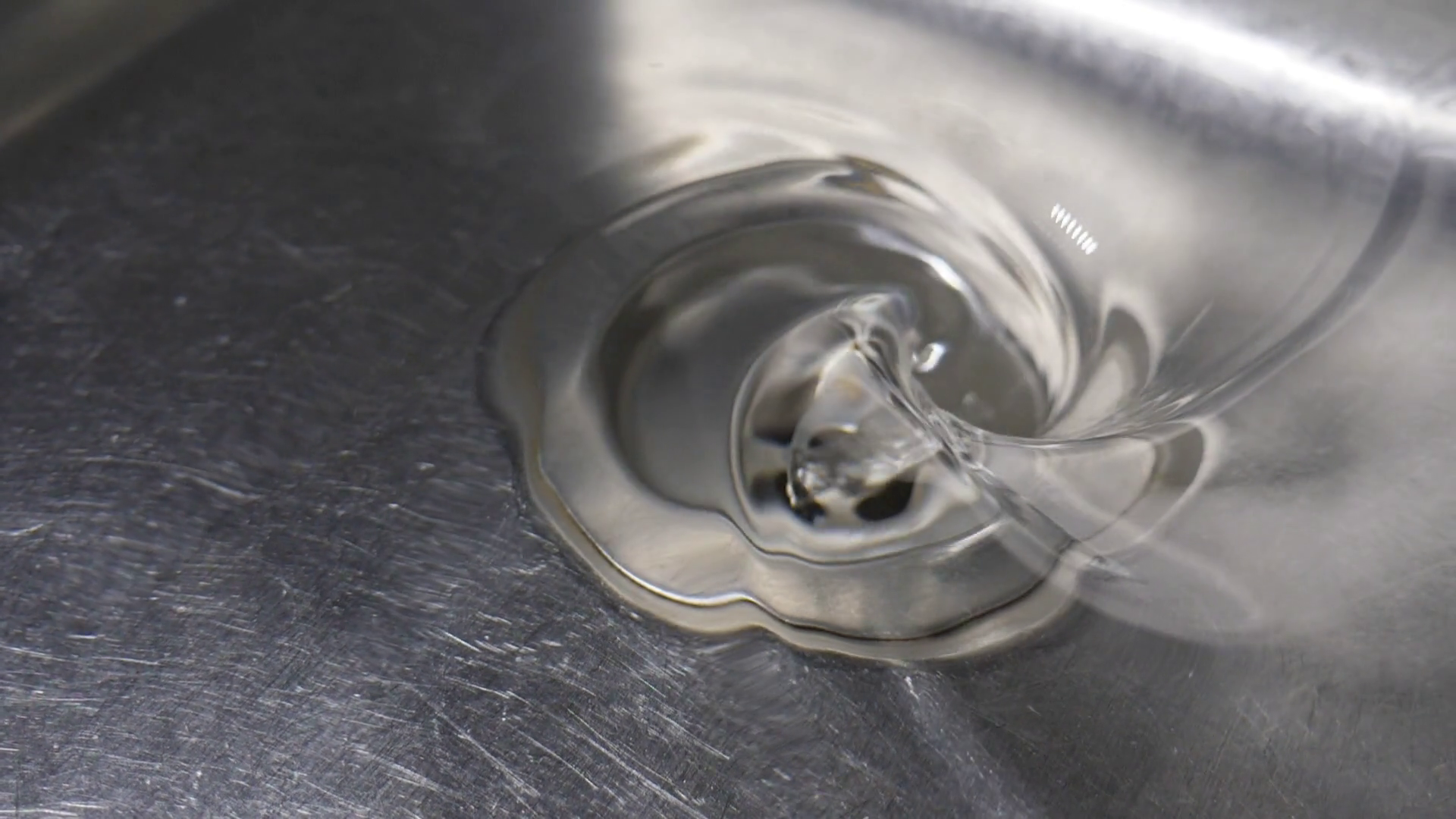 Slow motion swirl of water going down drain of kitchen sink. Stock ...