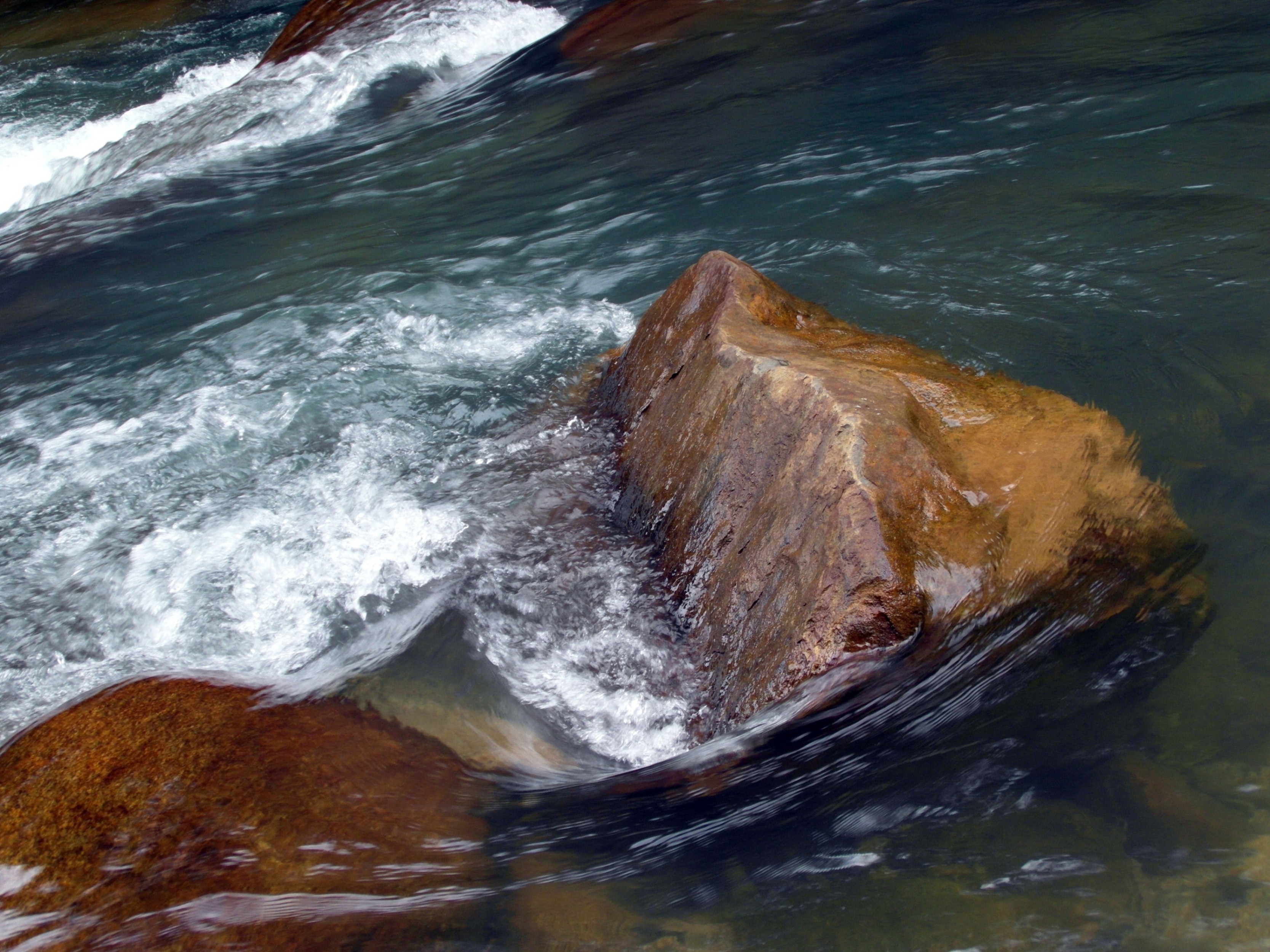 Water over smooth boulders in river photo