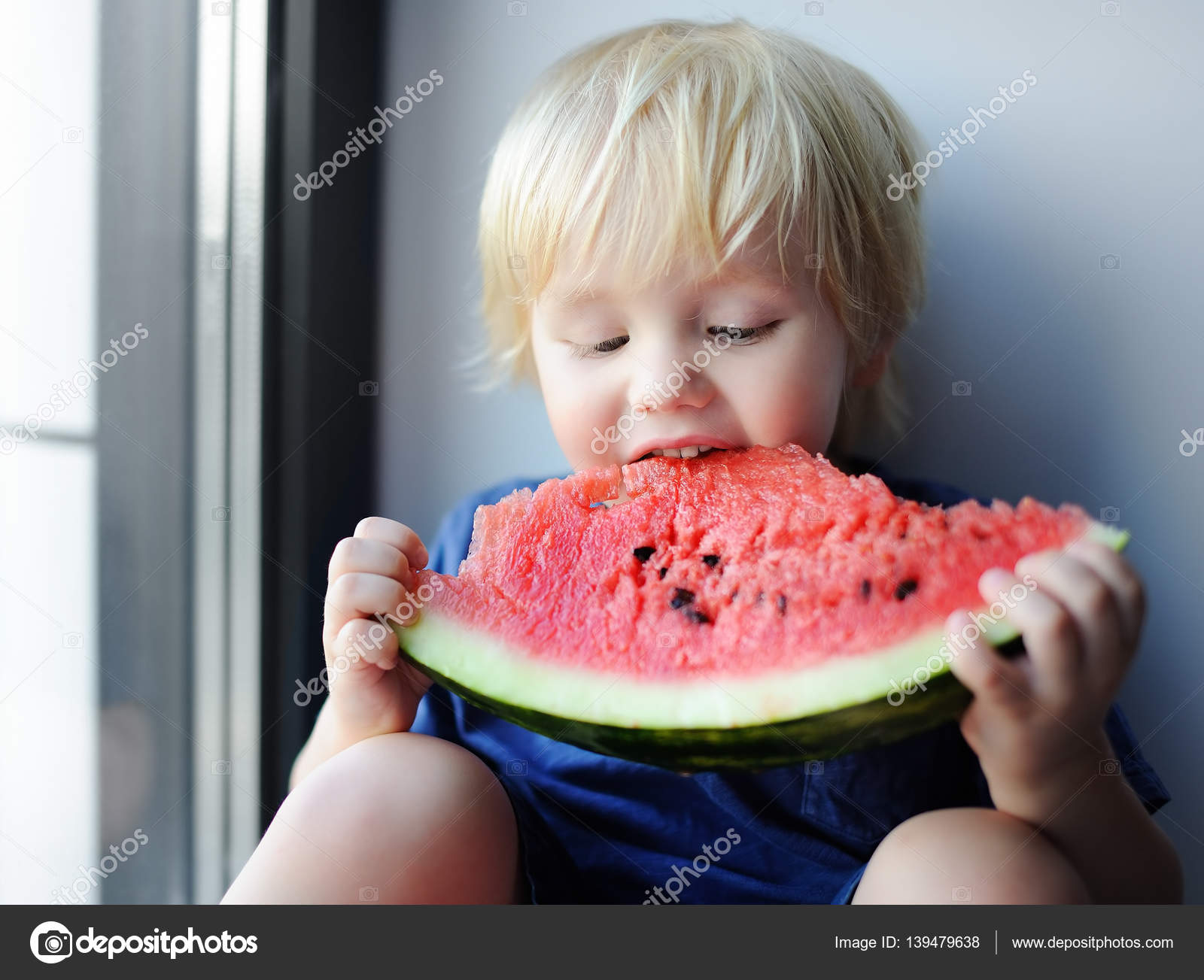 Cute little boy eating watermelon sitting on windowsill — Stock ...