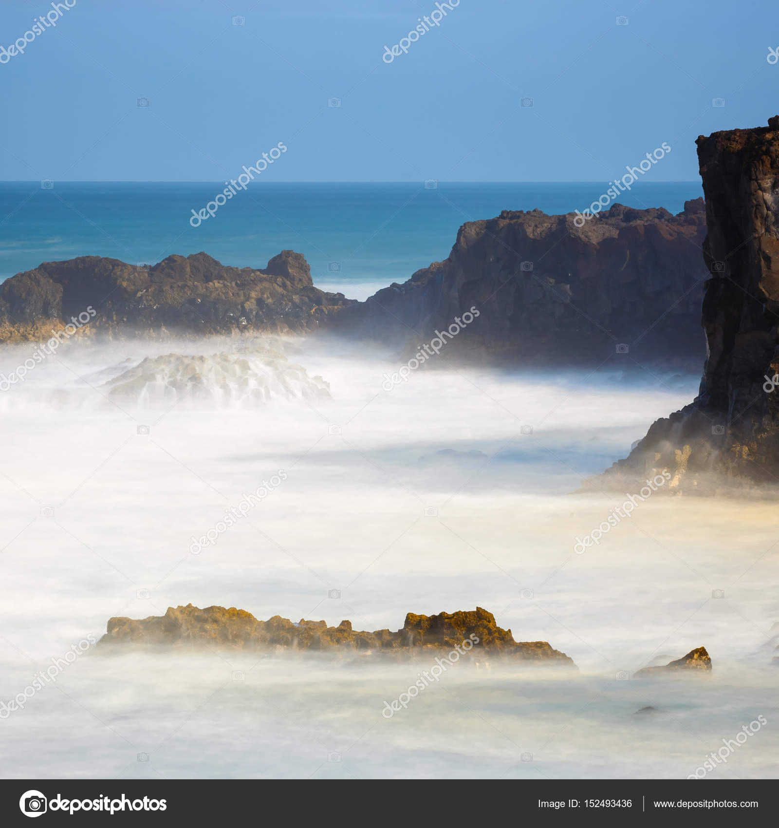 Los Hervideros, volcanic coastline with wavy ocean and blue sky ...