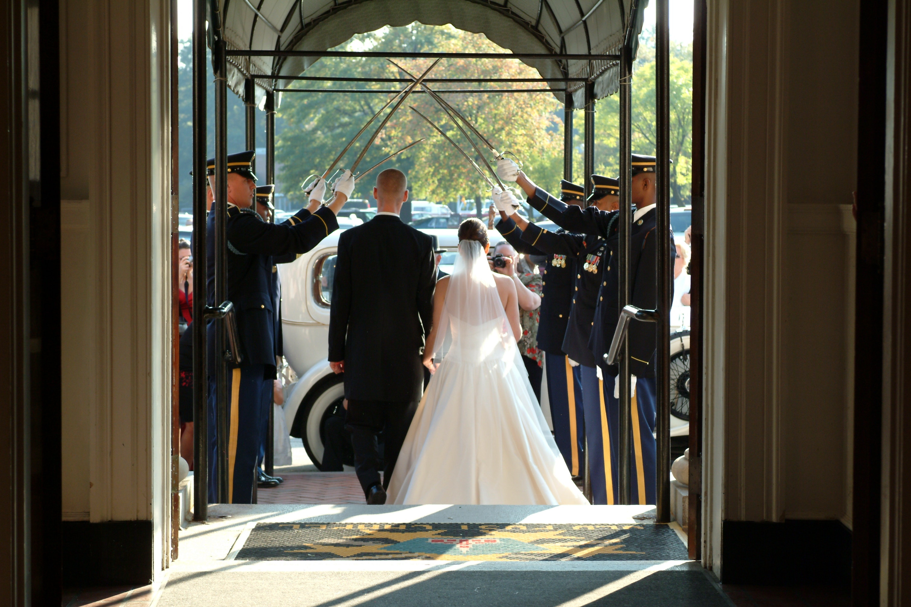 Wedding couple marching exit towards car at daytime photo