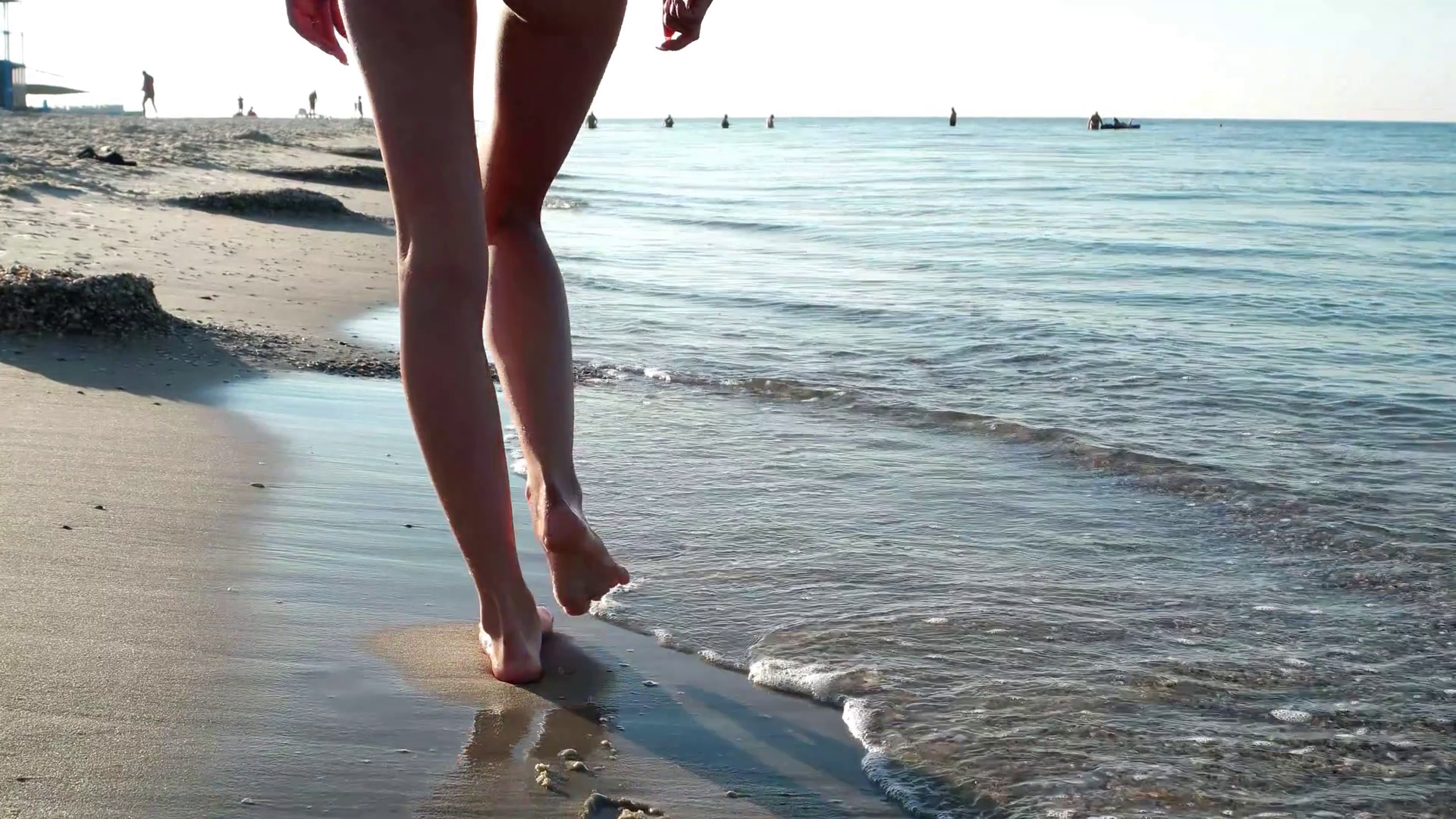 slender legs girls go on the water beach. girl goes barefoot on the ...