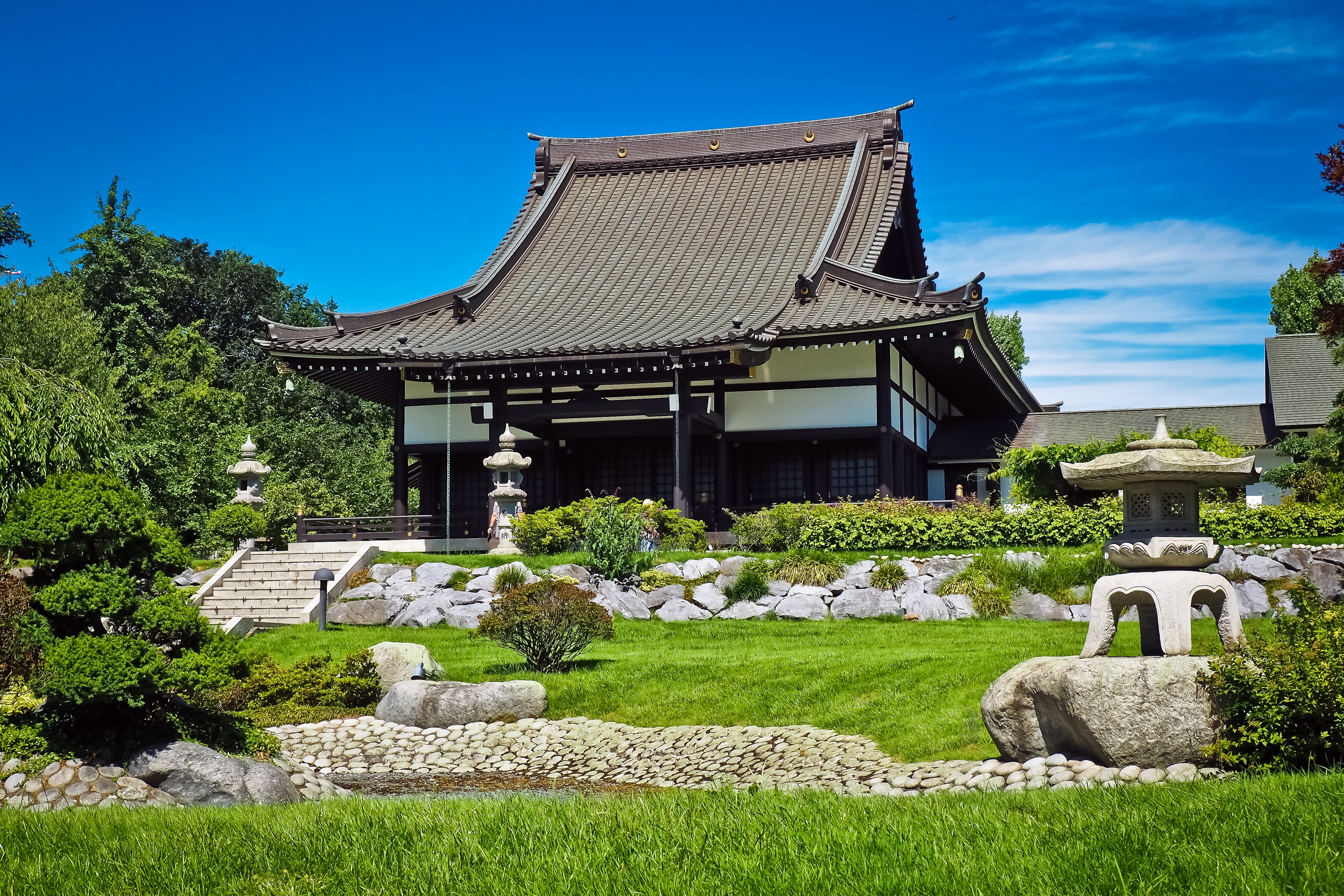 White and black temple surrounded by green grass field during daytime photo
