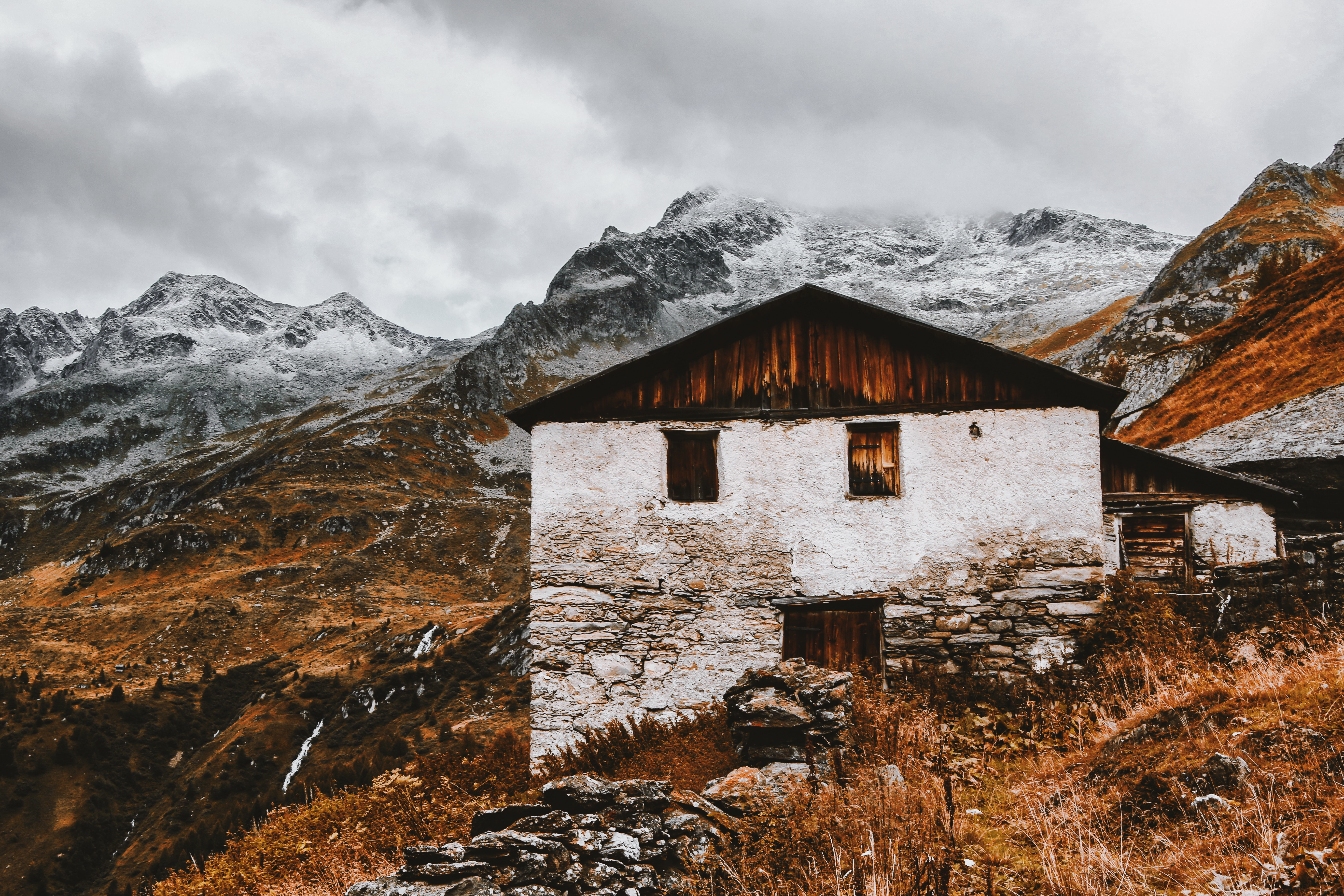 White and brown house near snow capped mountains photo