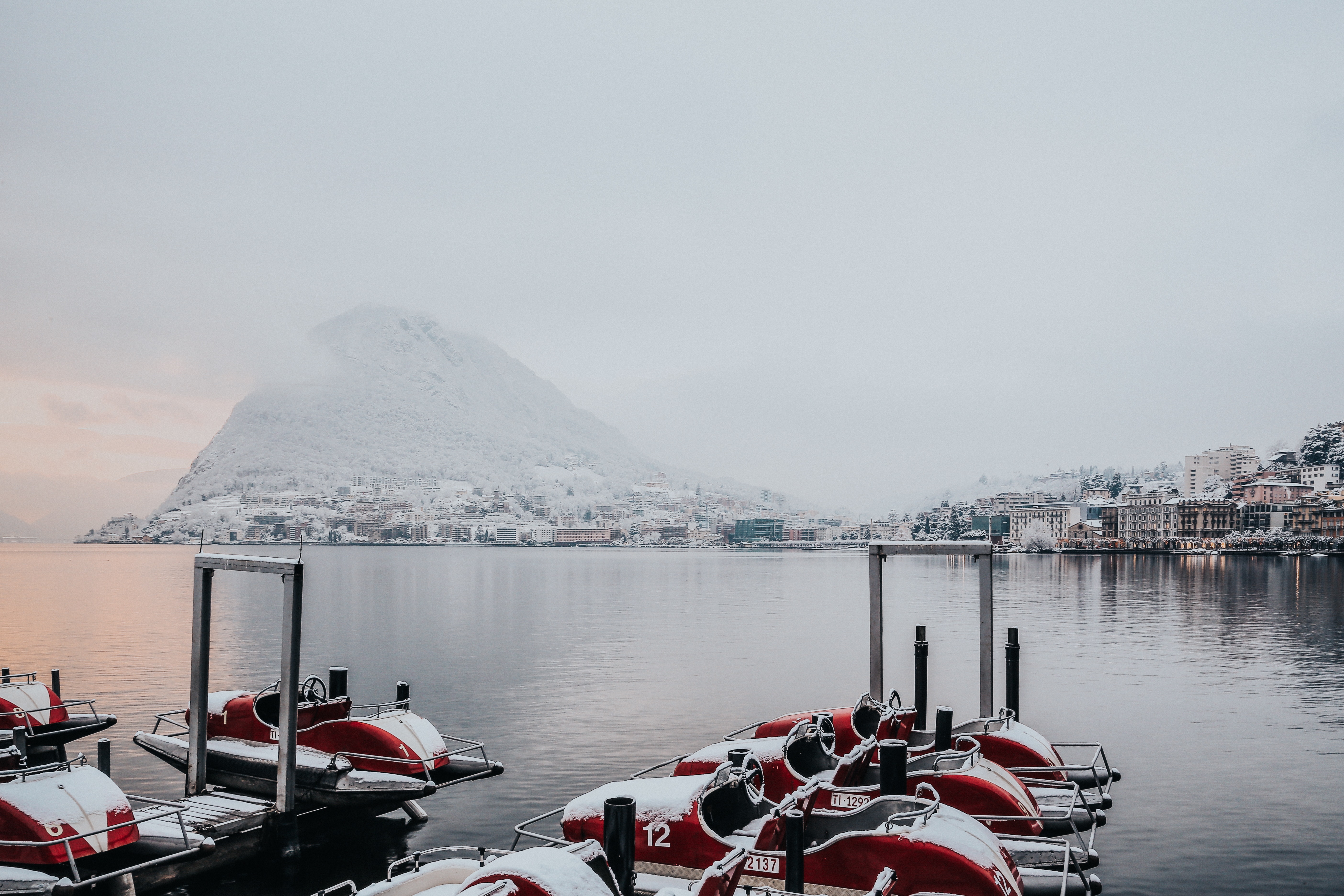 White and red boats on dock near white snowy mountain photo
