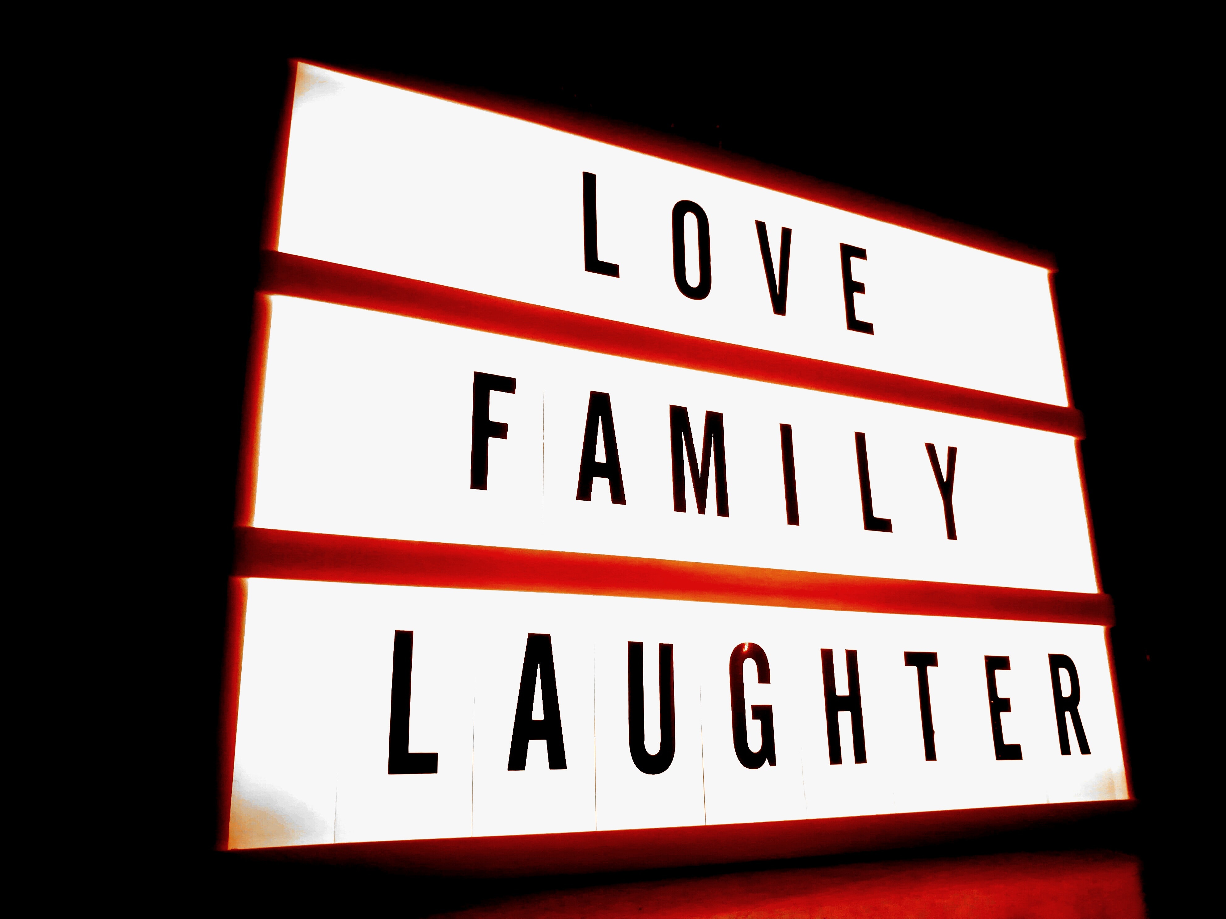 White and red led signage with love family laughter text photo