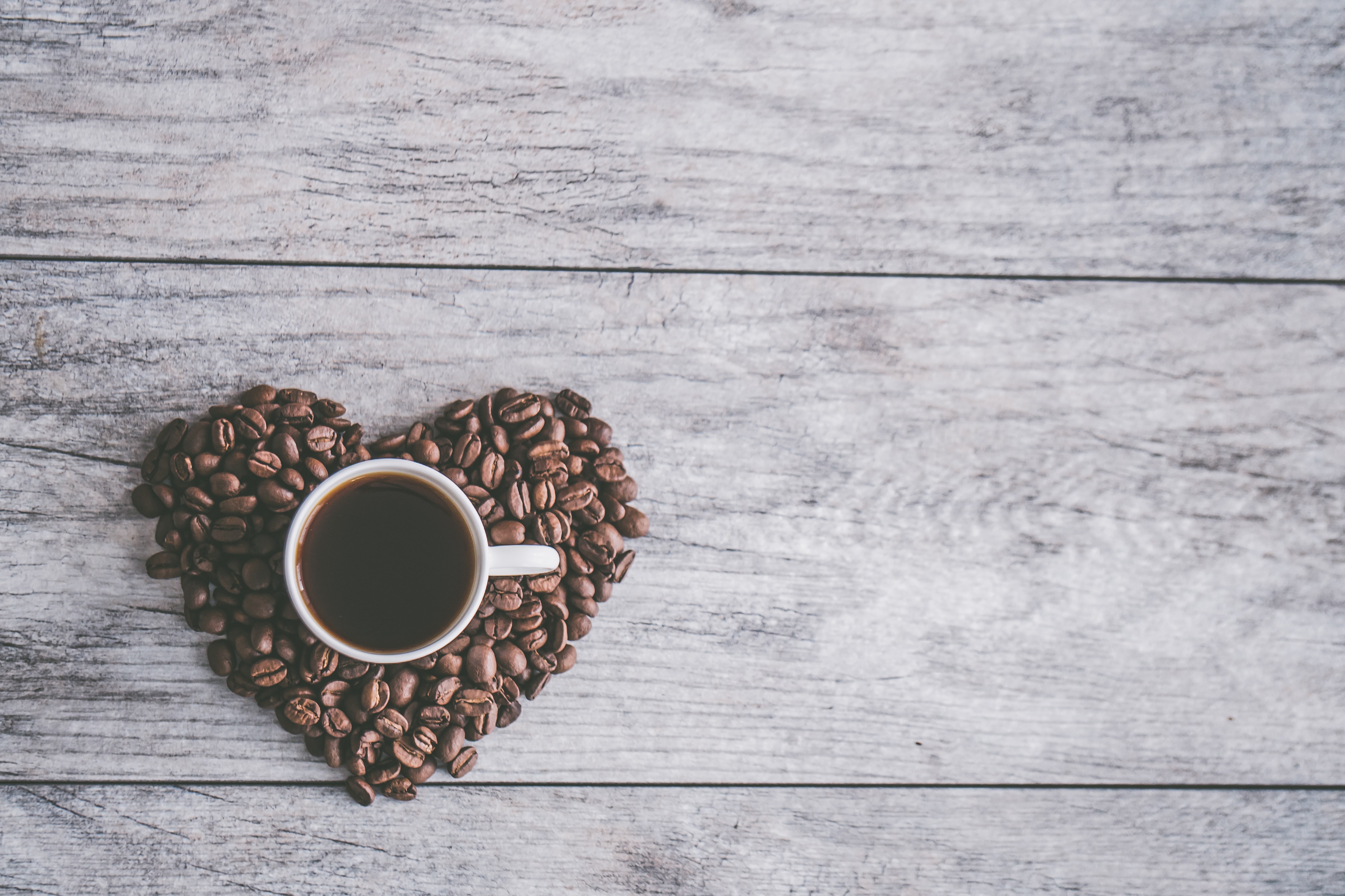 White Ceramic Mug Filled With Brown Liquid on Heart-shaped Coffee Beans, Background, Flatlay, Wood, Texture, HQ Photo