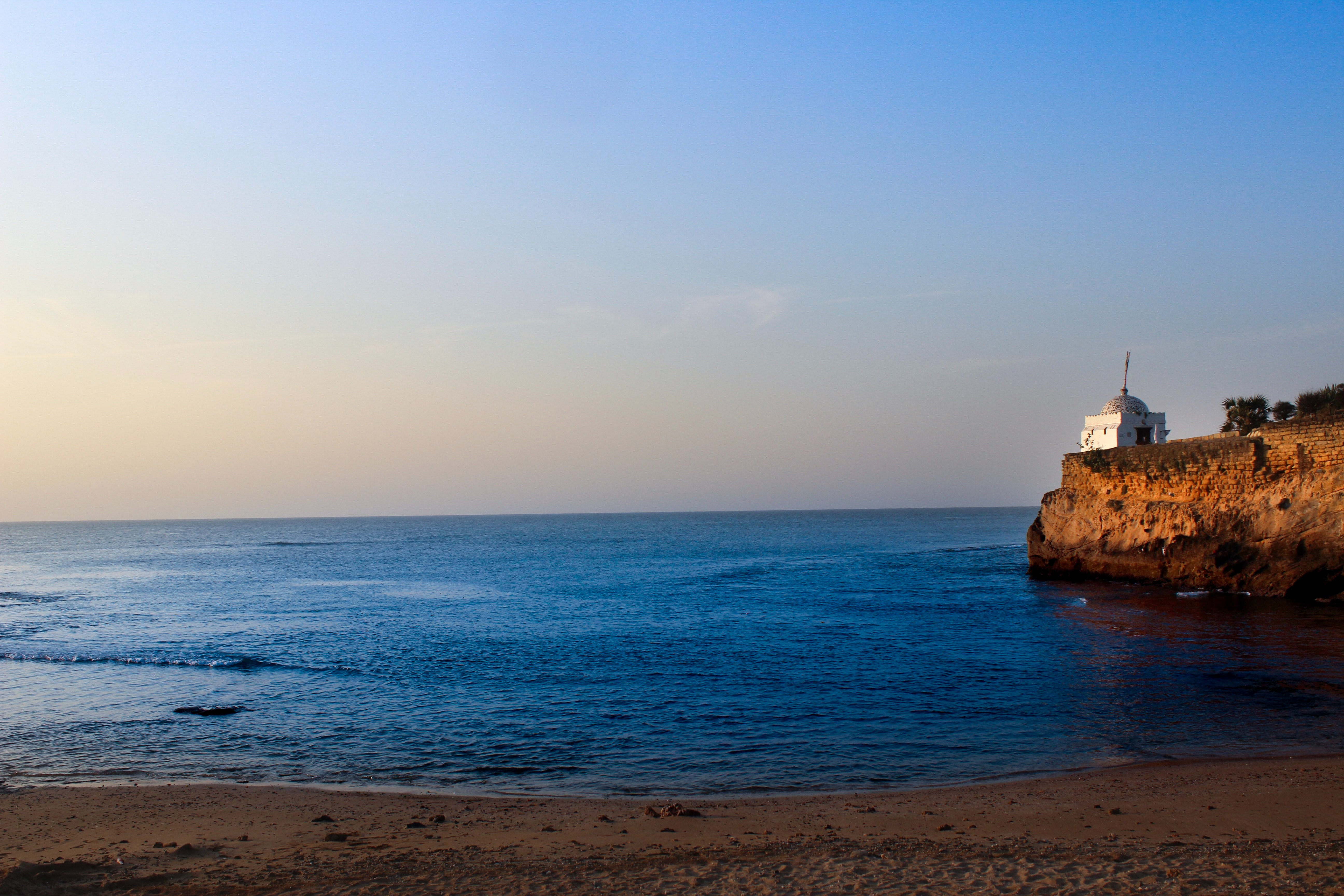 White lighthouse near sea under blue sky photo