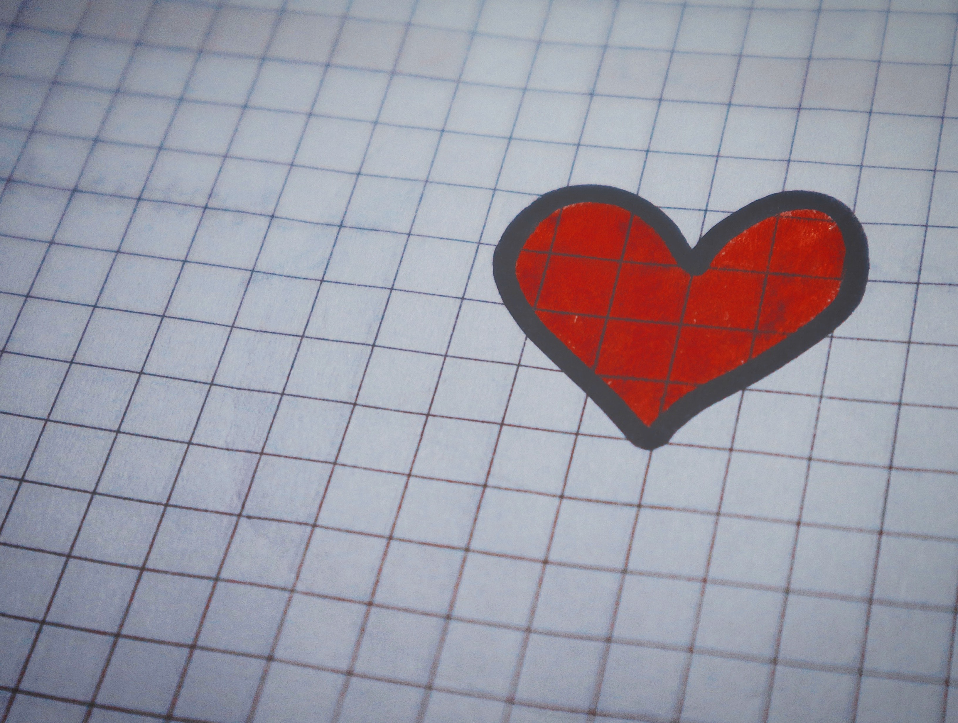 White page of graphing paper with red heart drawing photo