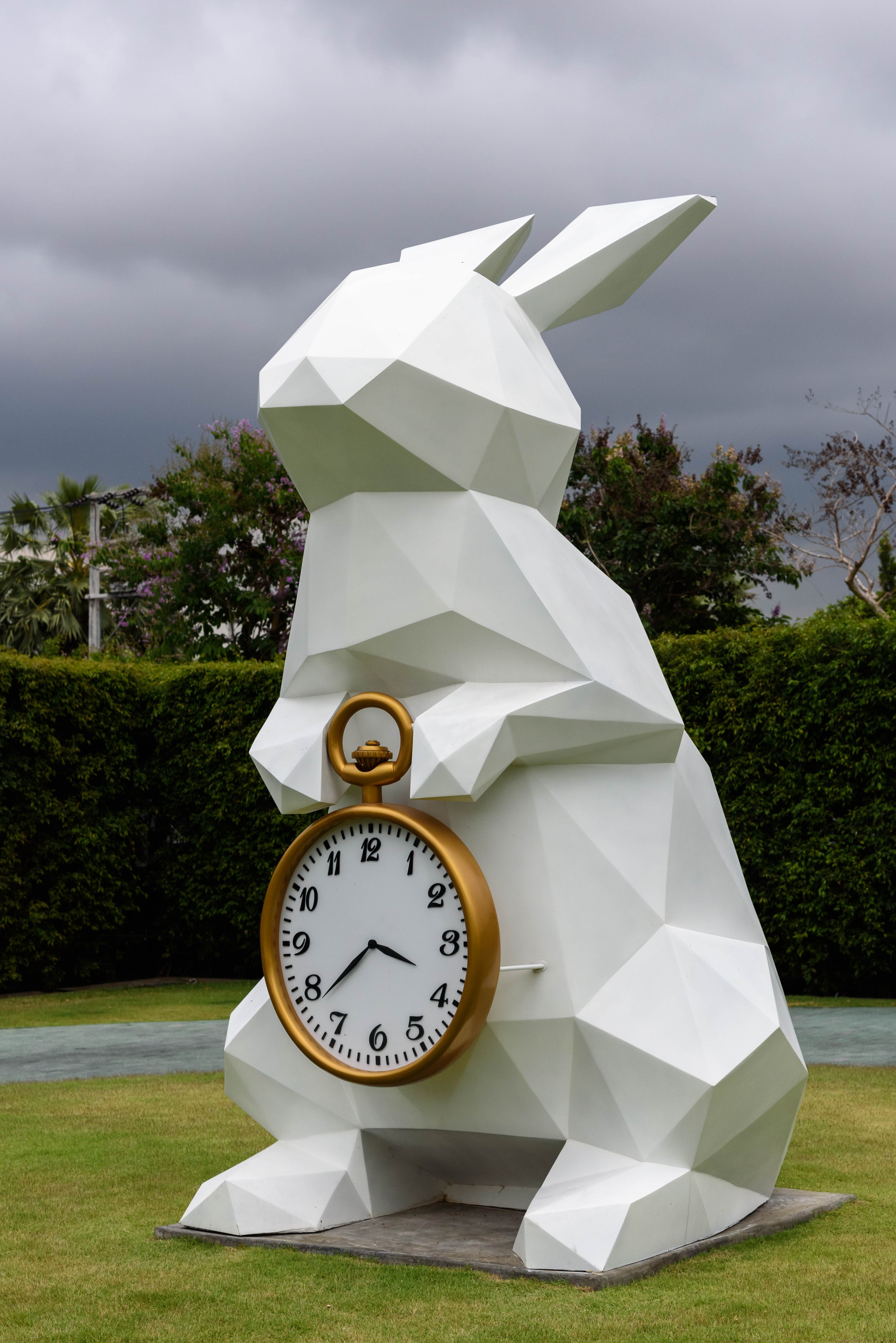 White rabbit holding gold frame pocket watch statue photo