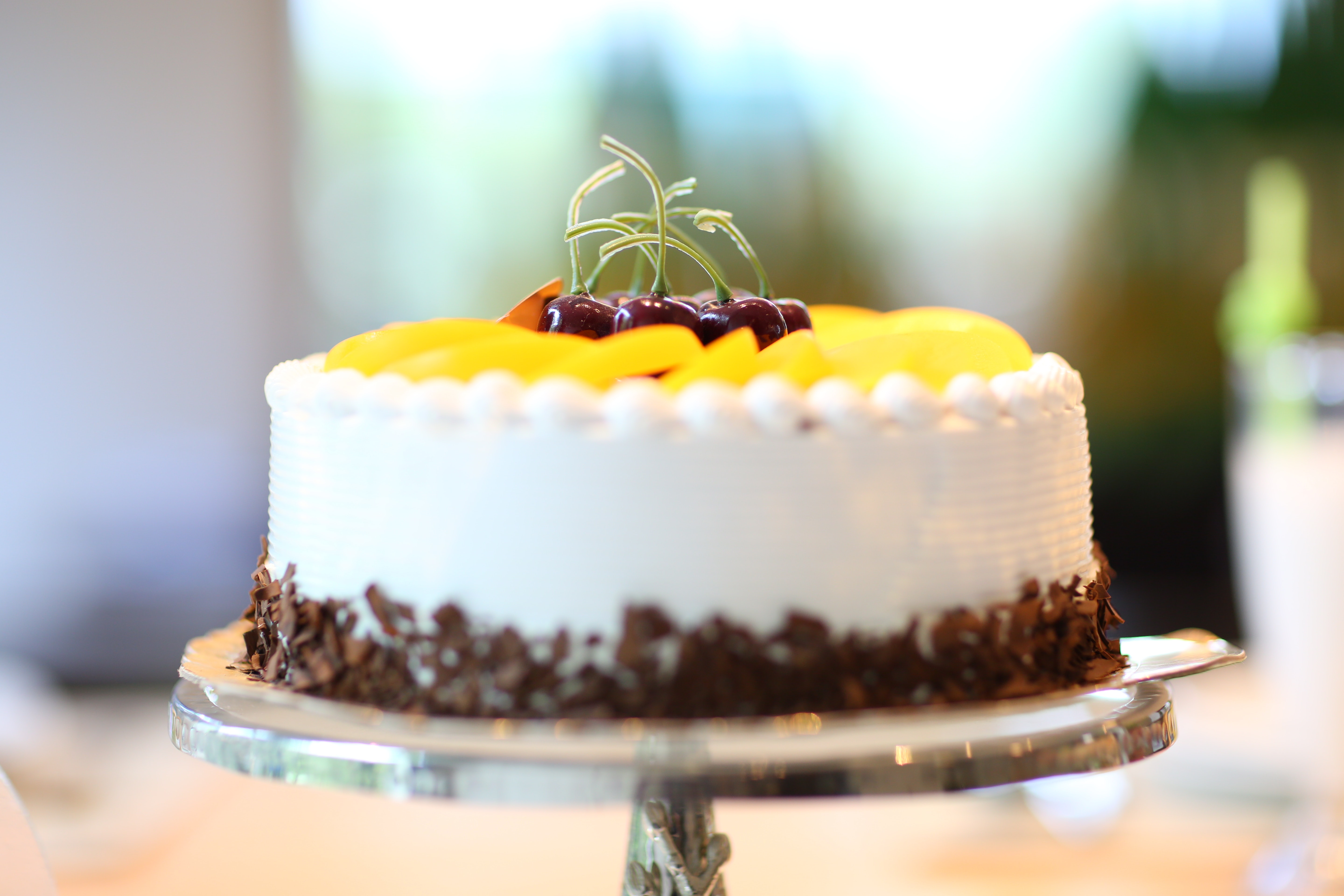 White round cake topped with yellow slice fruit photo