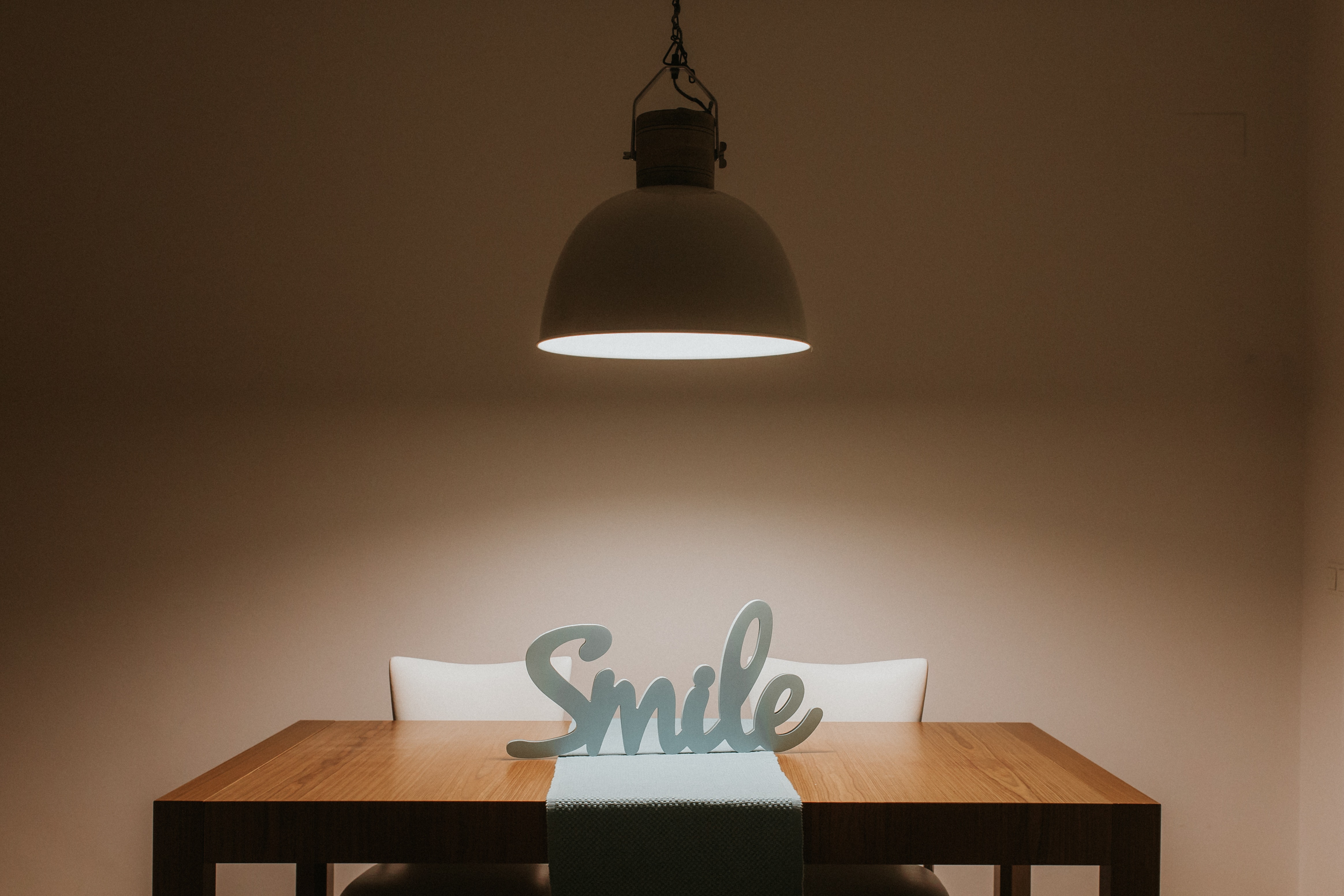 White smile cutout signage on table photo