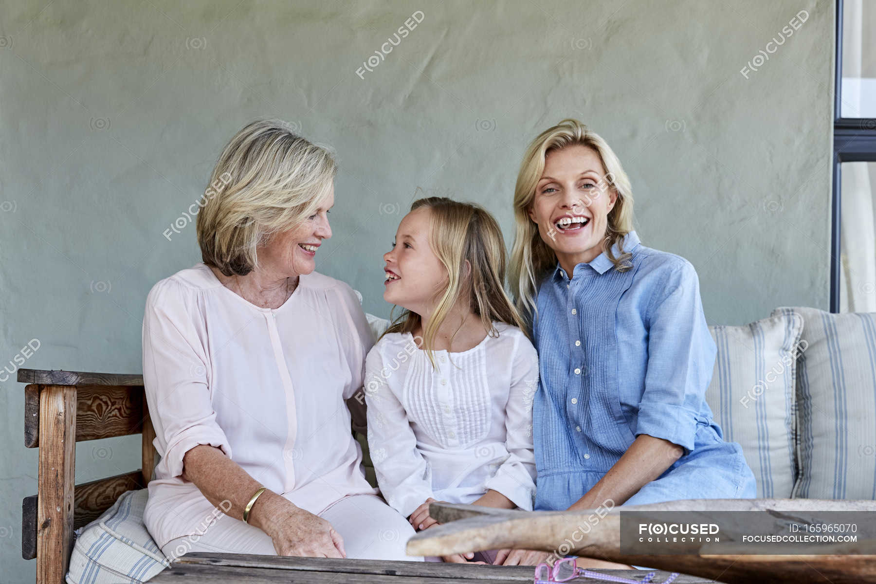 Girl sitting together with grandmother and mother — Stock Photo ...