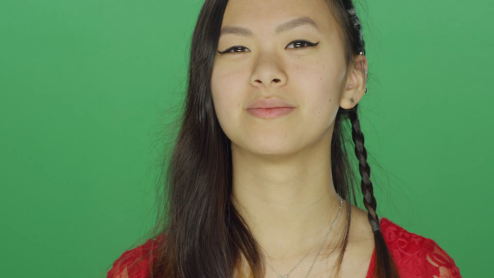 Young Asian woman smiling and being playful, on a green screen ...