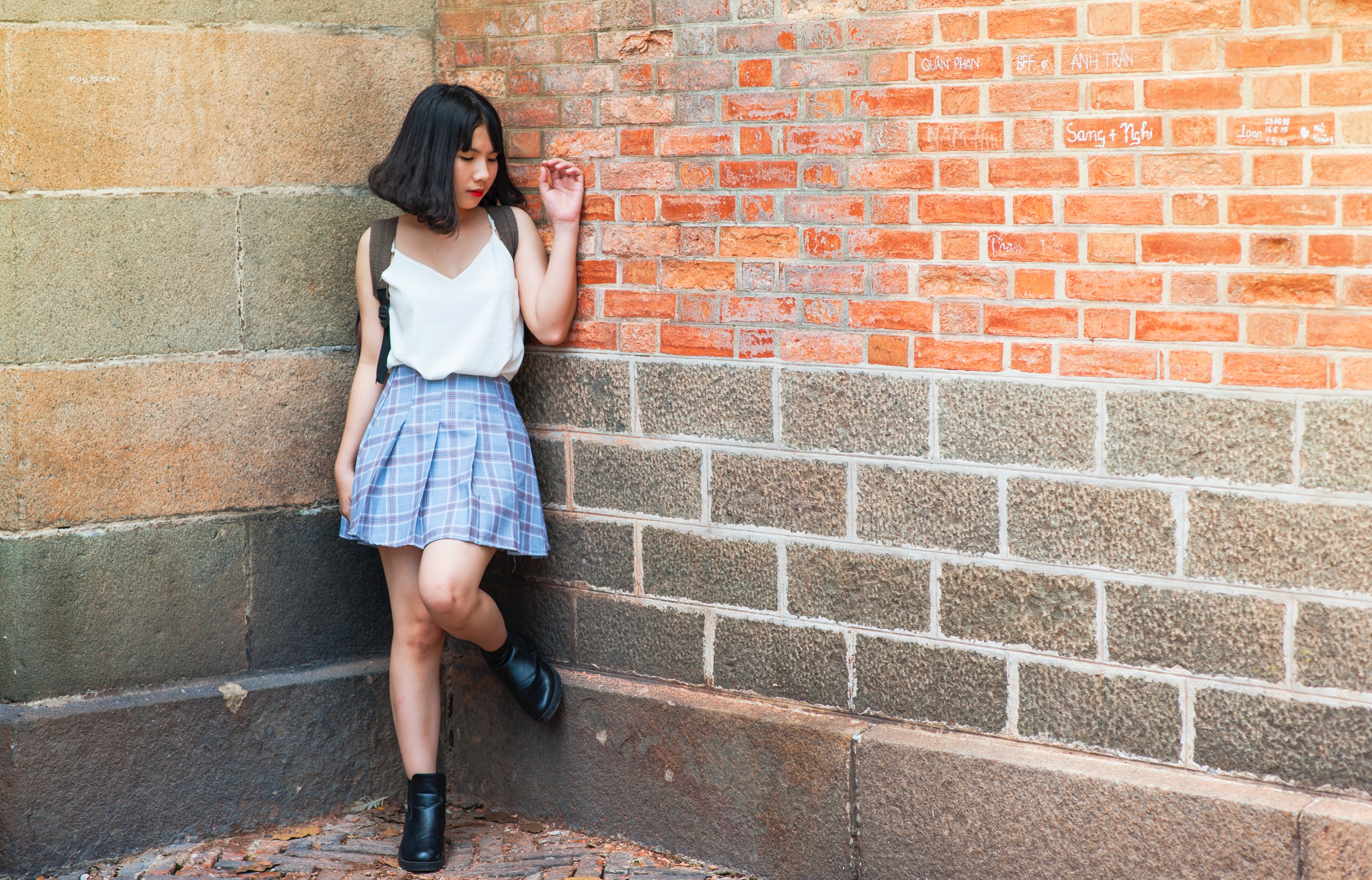 Woman beside brick and cinder wall photo