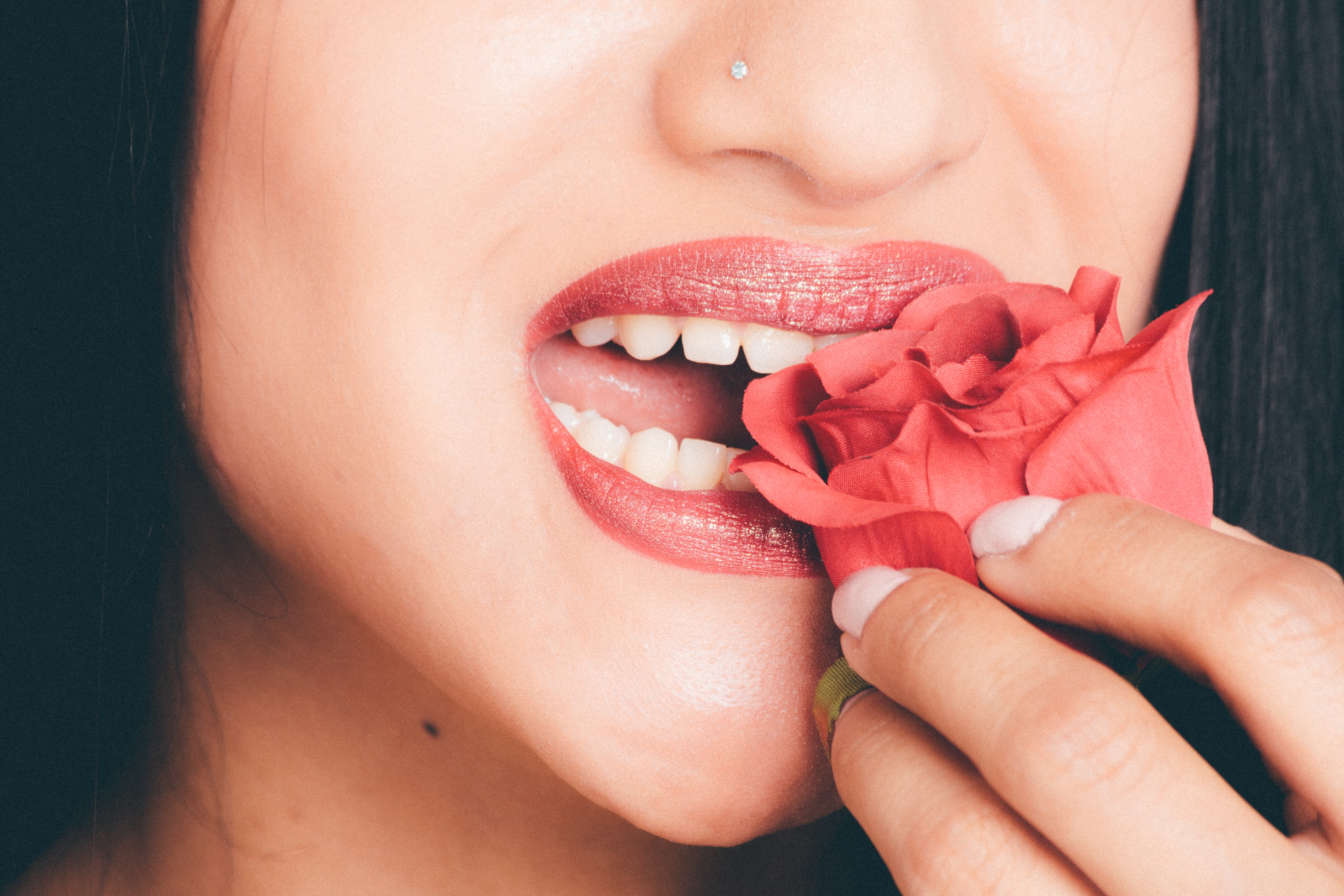 Woman biting the red rose photo