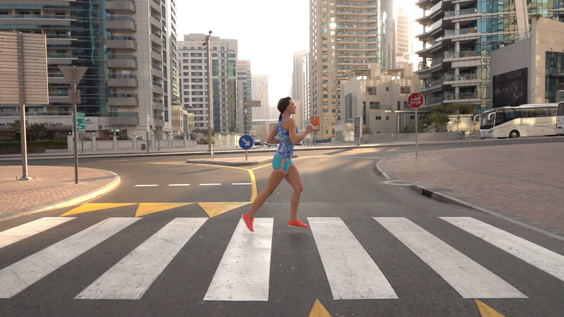 Young woman jogging in city, crossing zebra, super slow motion ...