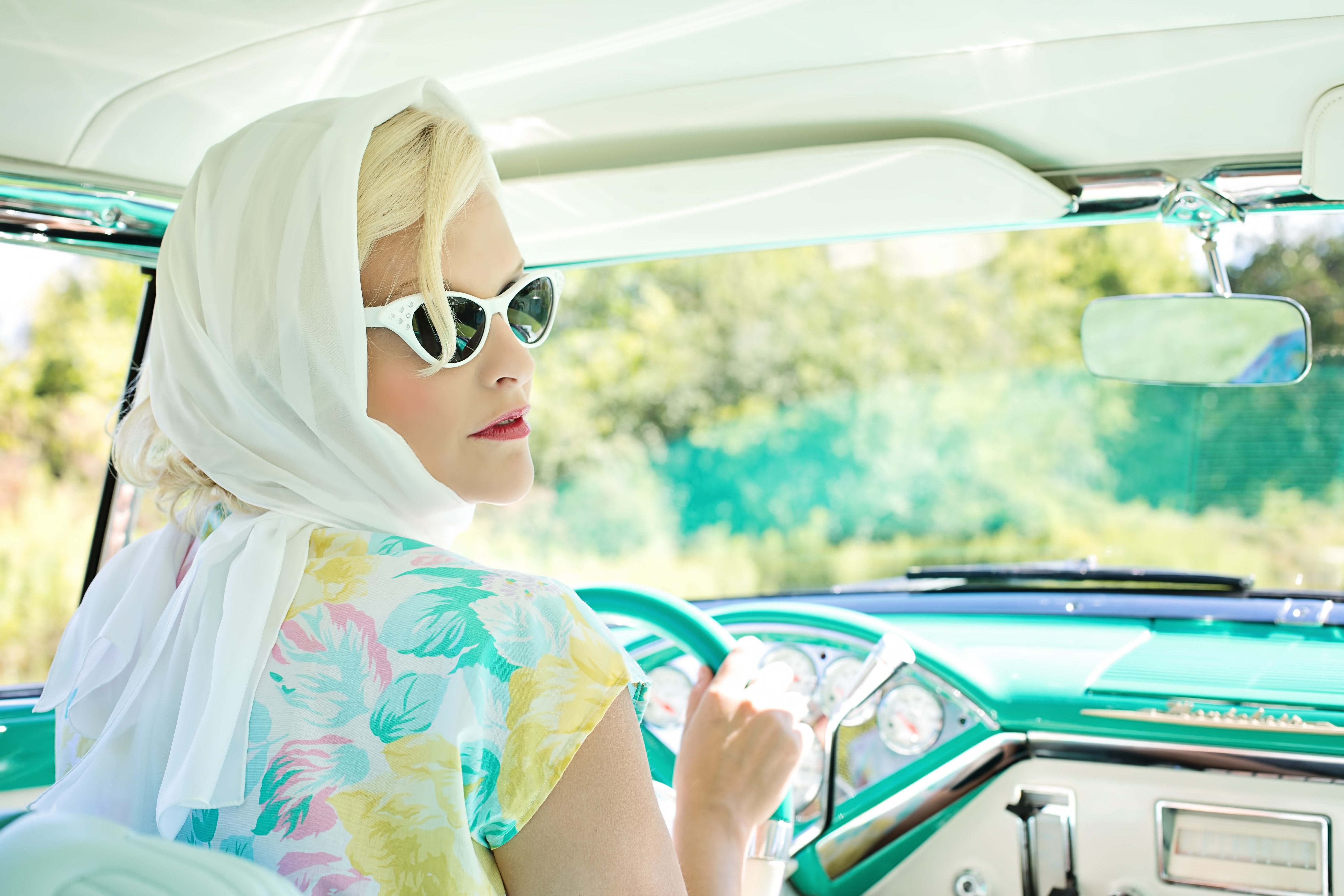Woman driving vintage car on road during daytime photo
