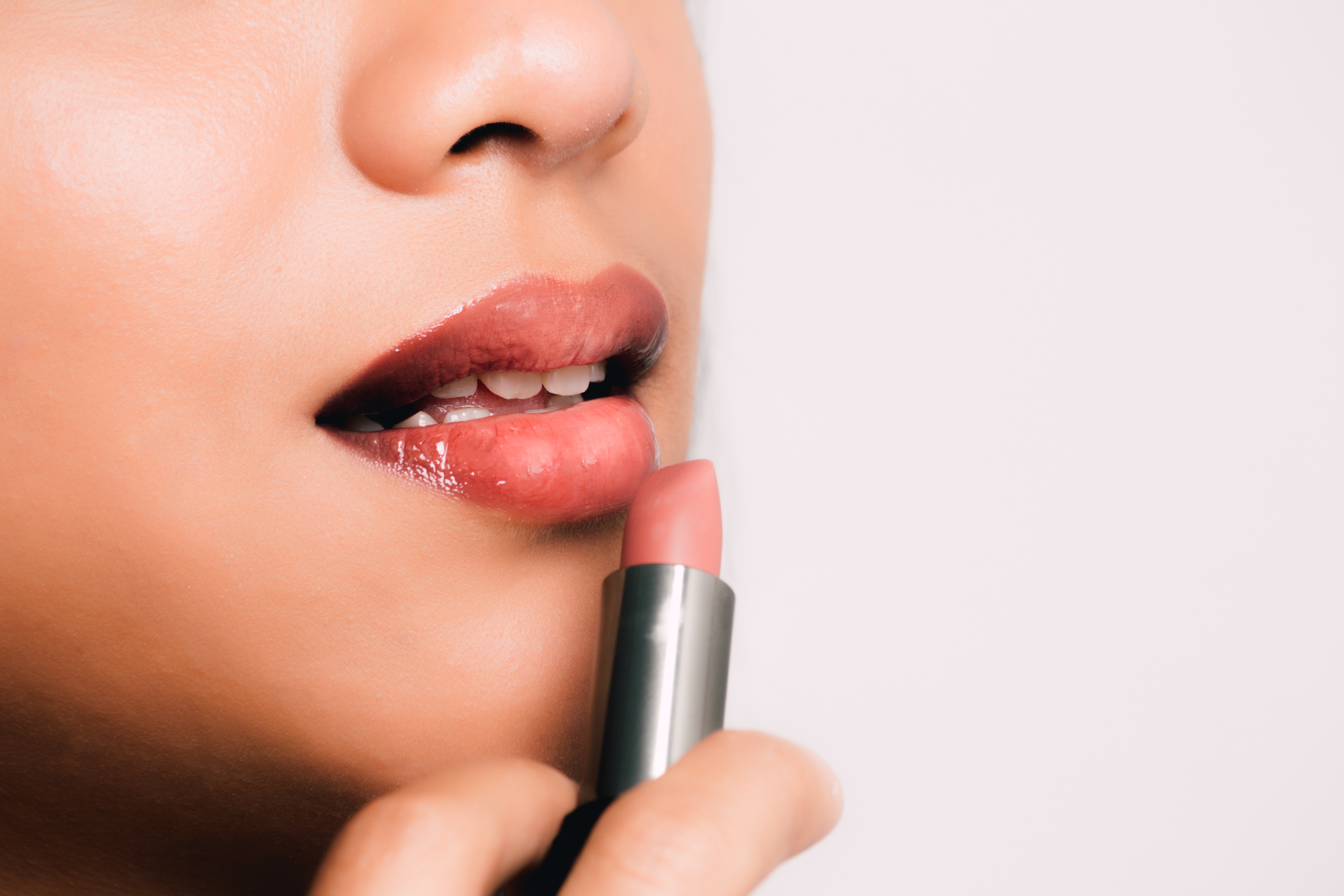 Woman holding a pink lipstick photo