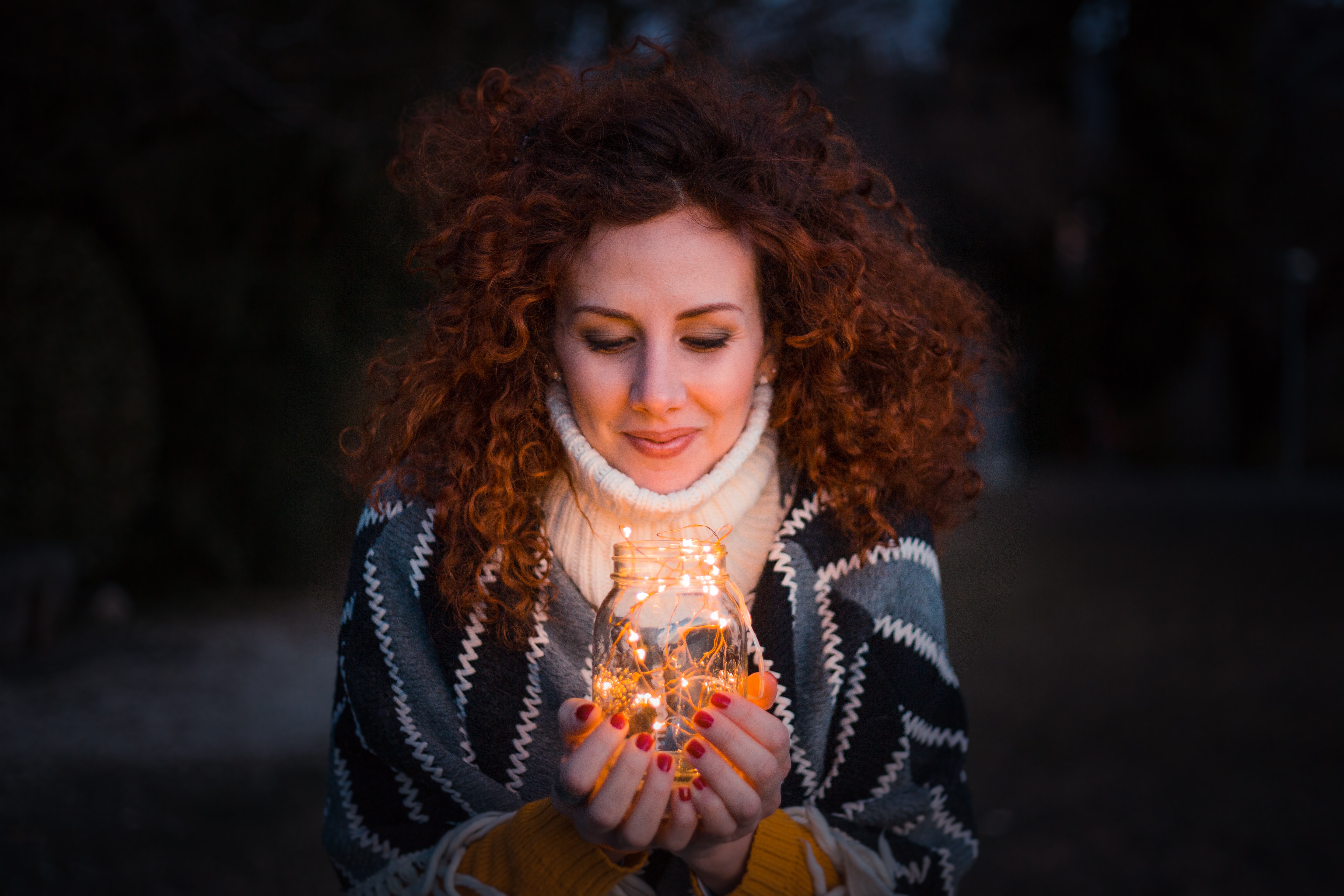 Woman holding clear glass jar filled with lights photo