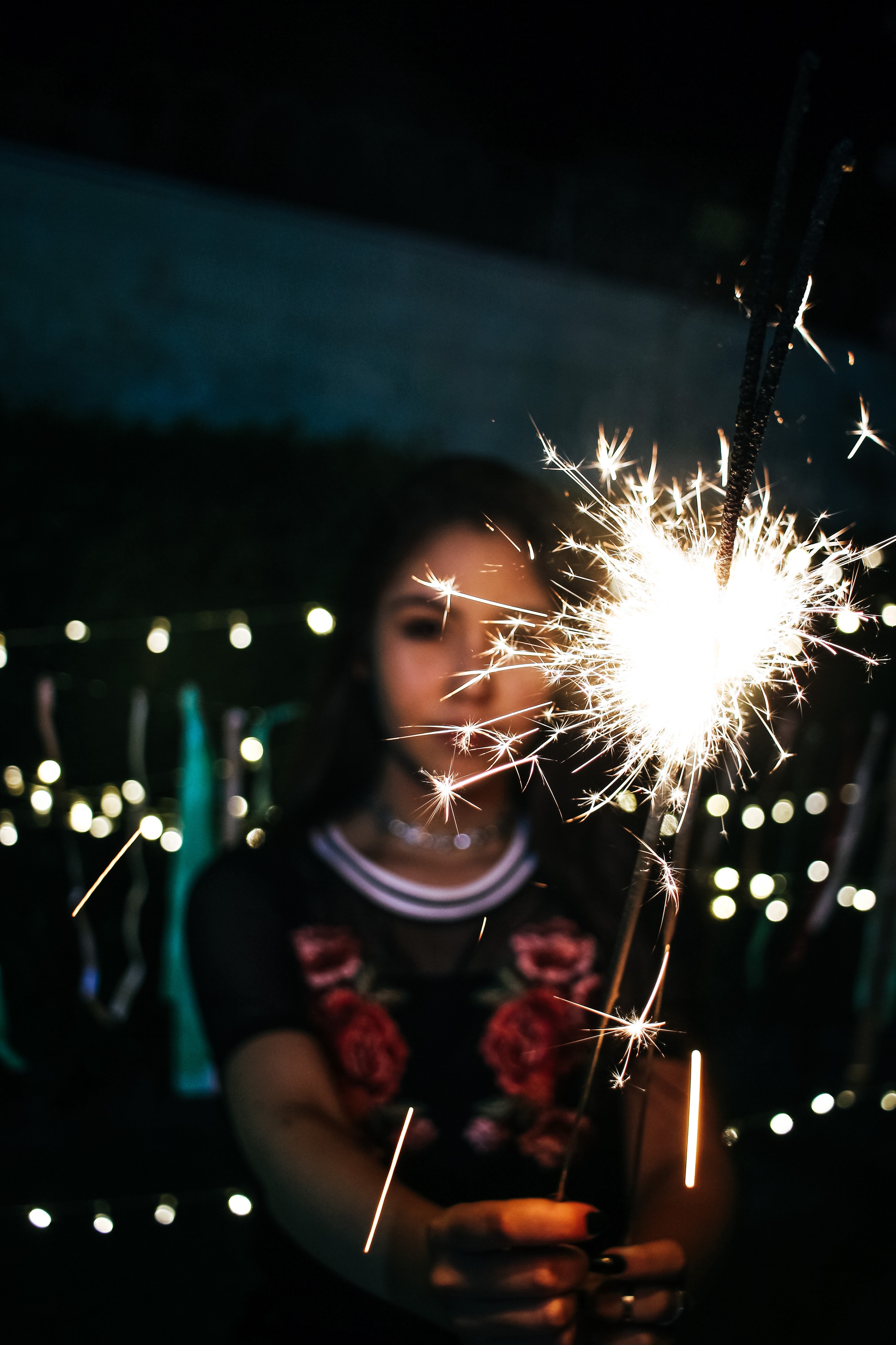 Woman holding sparkle during nighttime photo