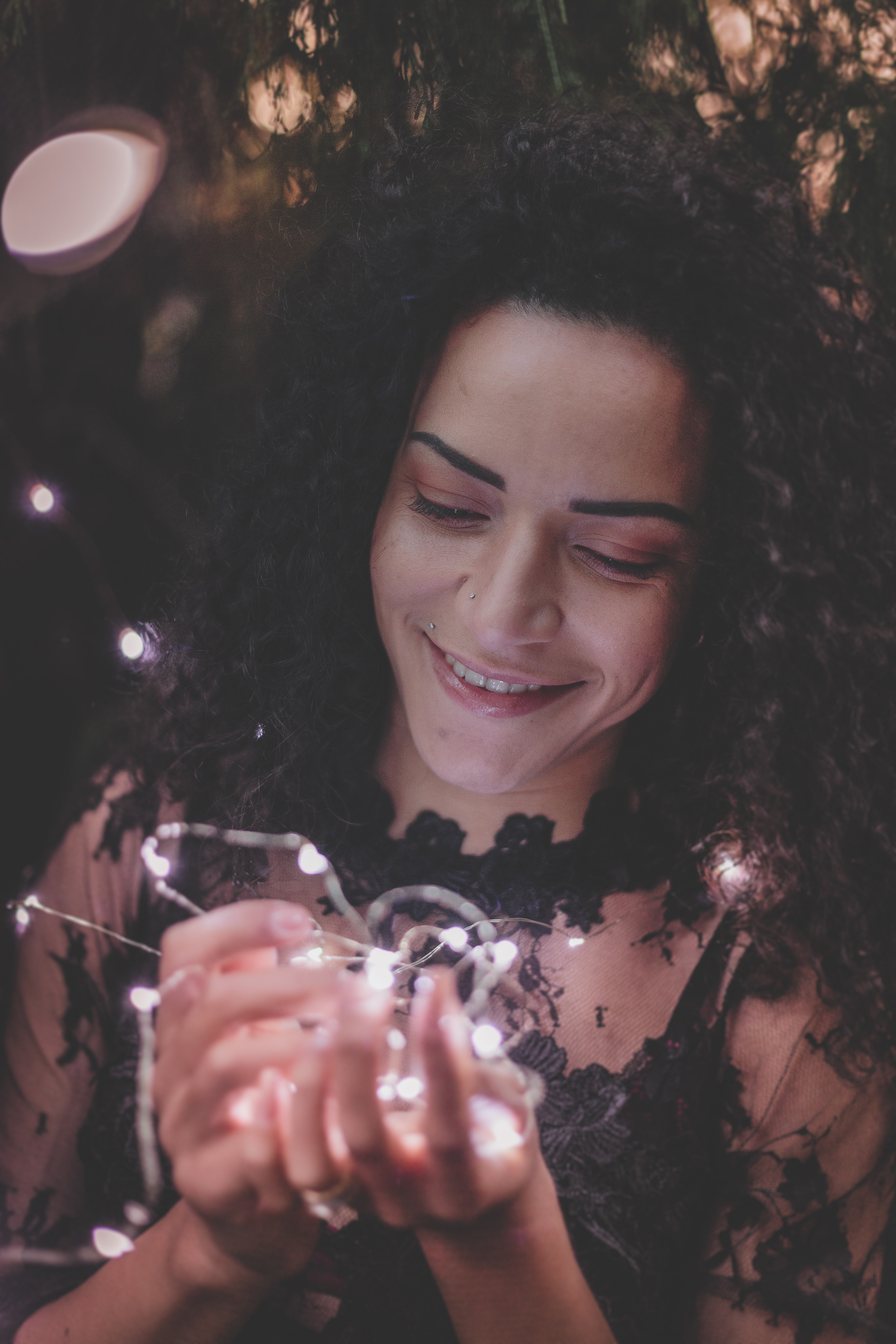 Woman holding string lights while smiling photo