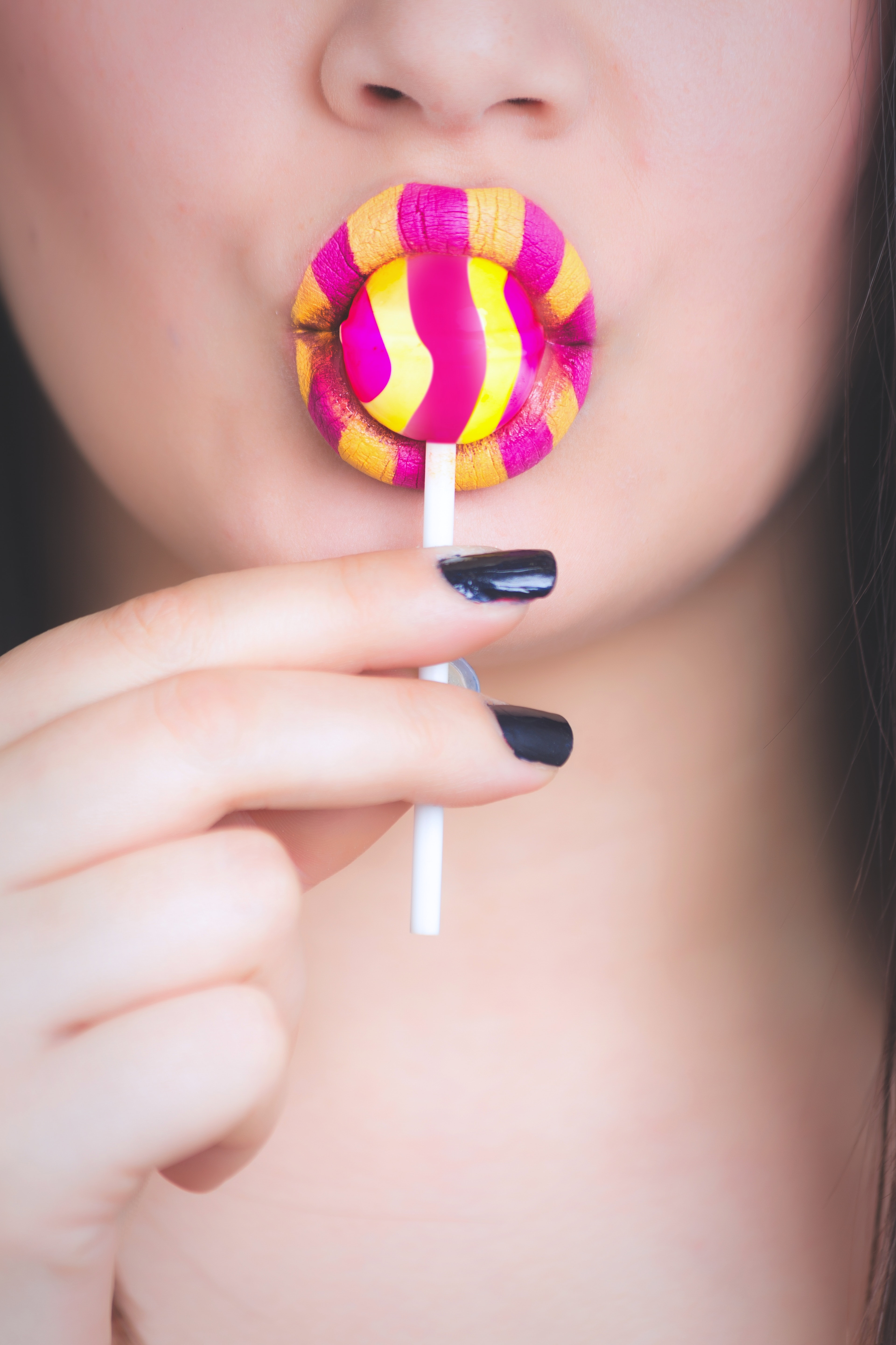 Woman holding yellow and pink candy photo