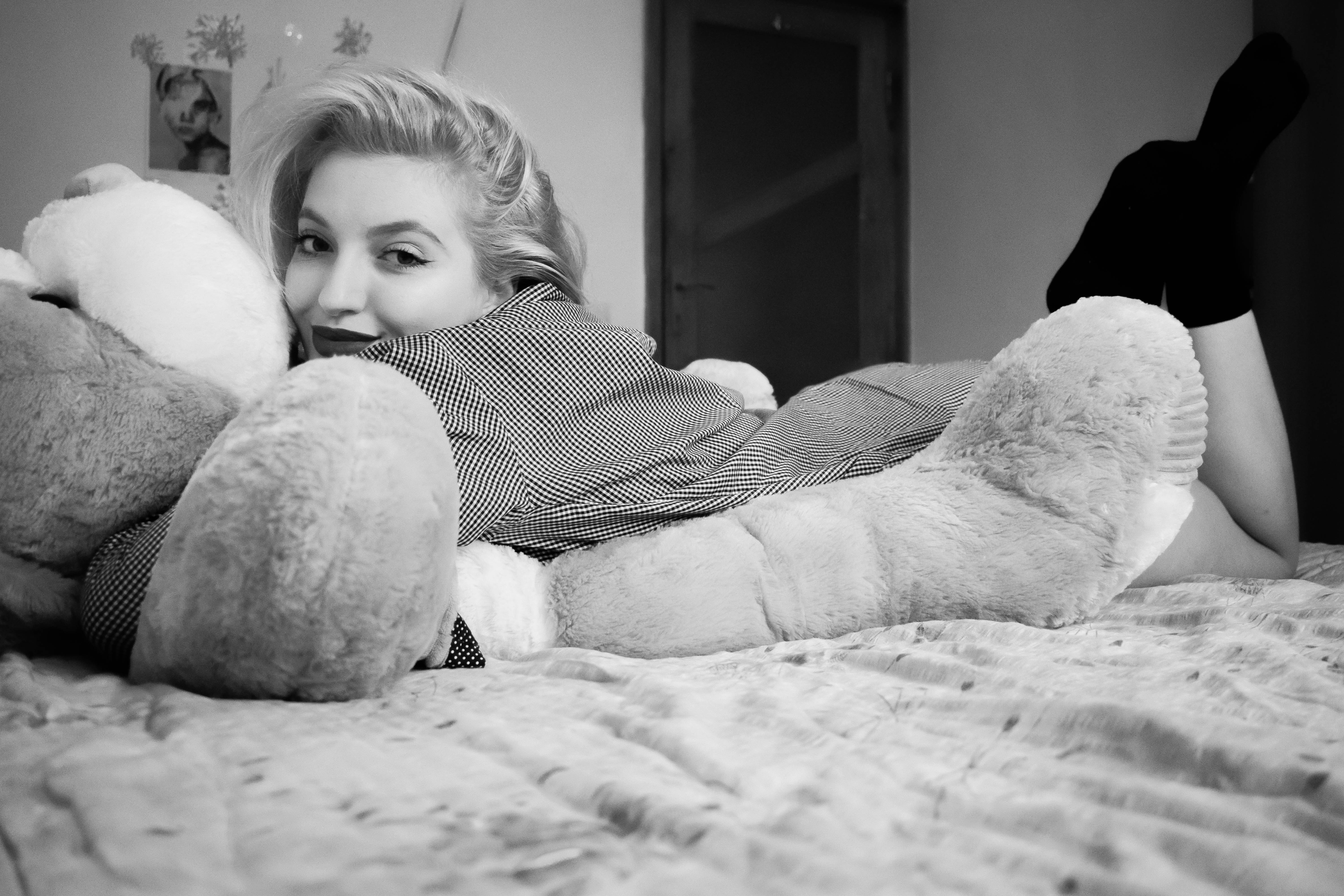 Woman hugging bear lying on bed photo