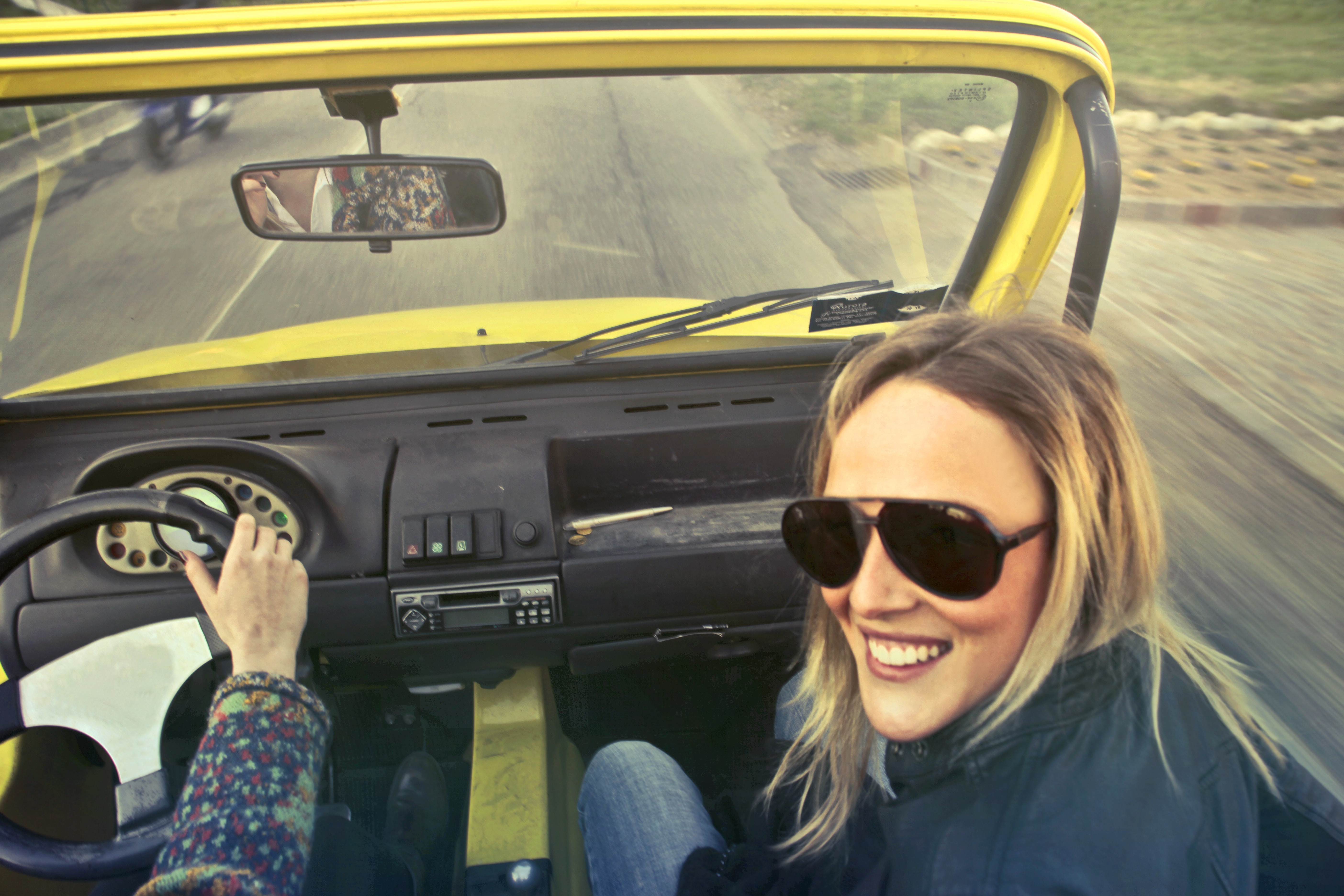 Woman in black aviator sunglasses sitting on car's passenger seat photo