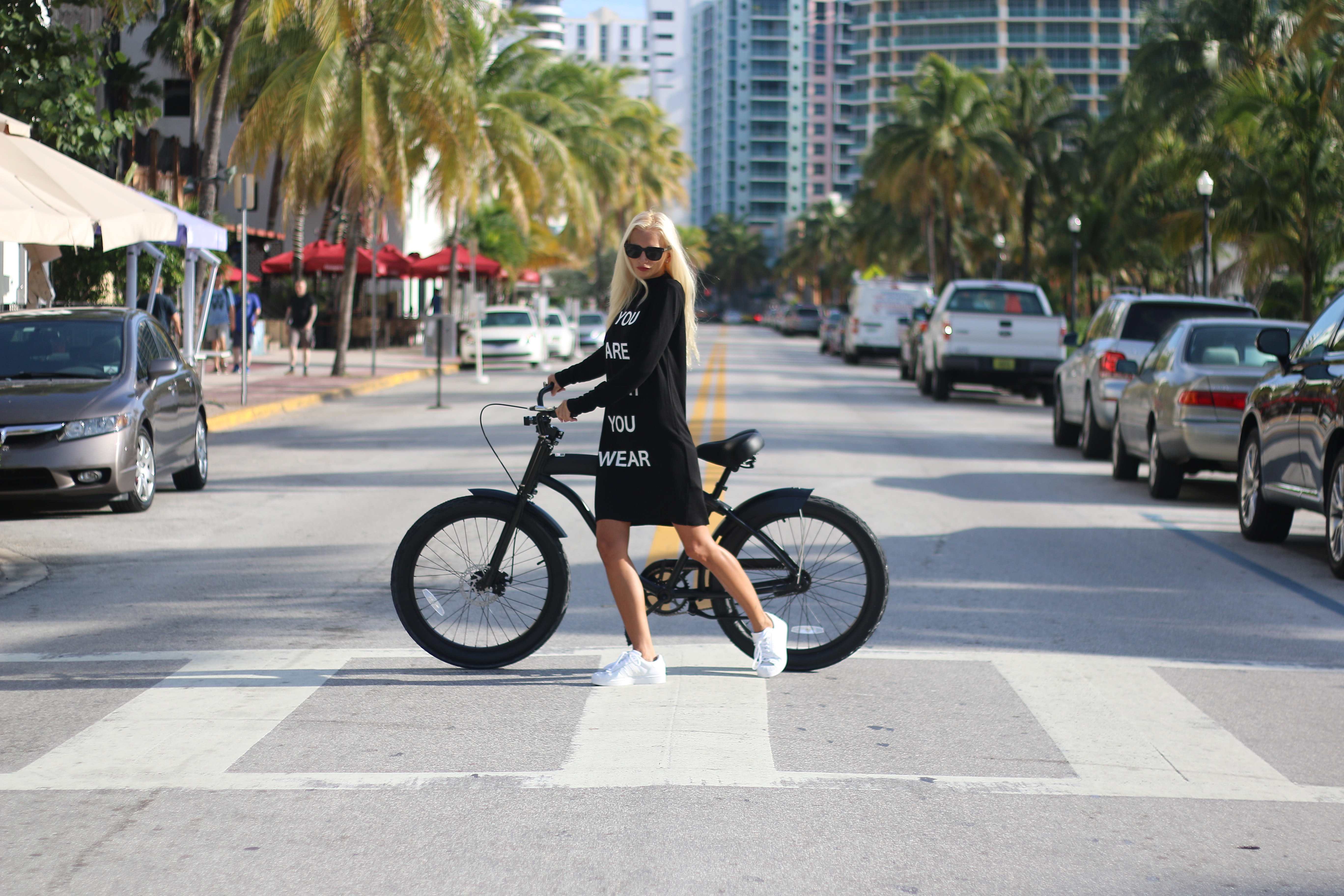 Woman in black long sleeve shirt holding bicycle photo