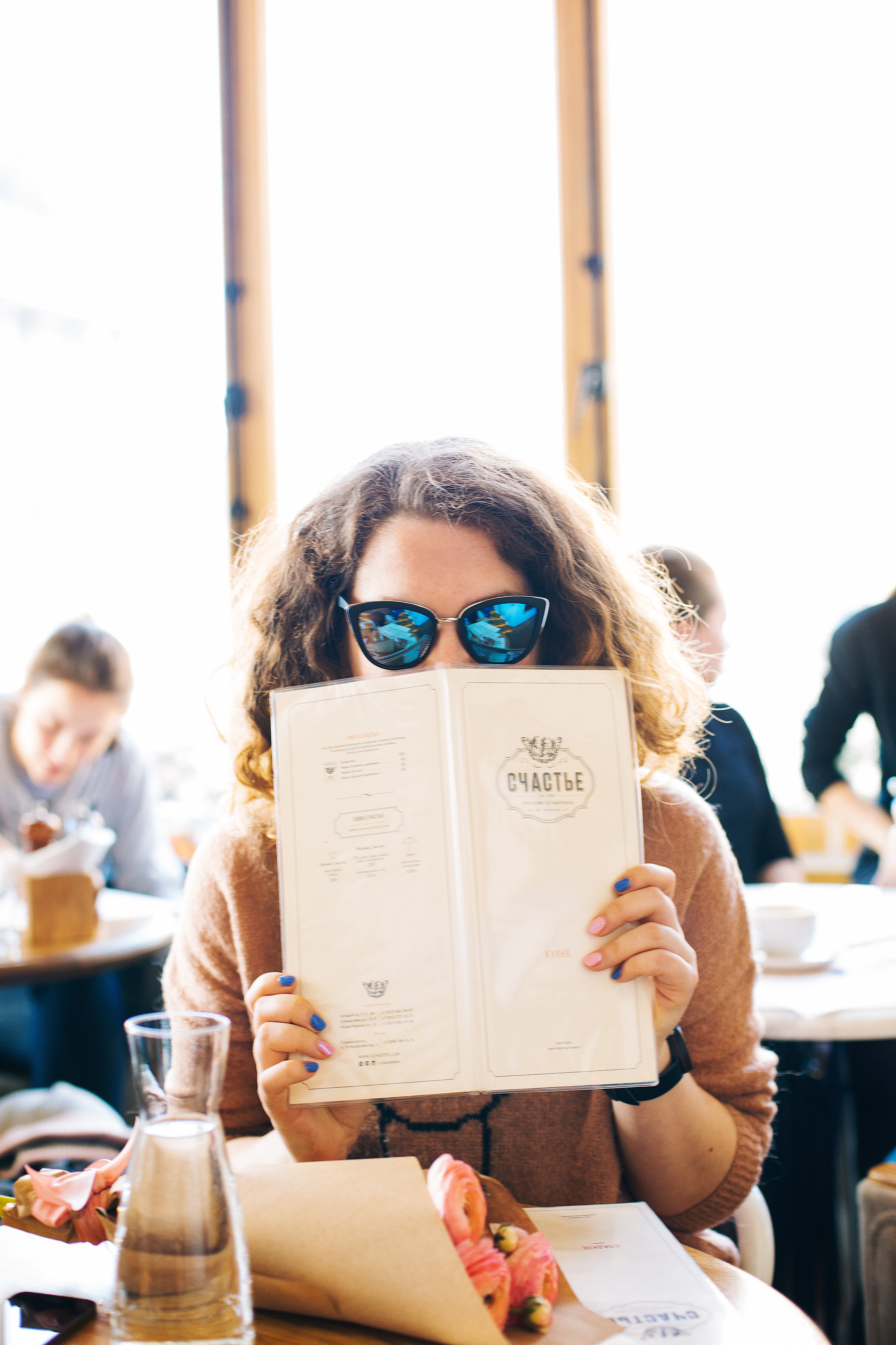 Woman in black sunglasses holding menu photo